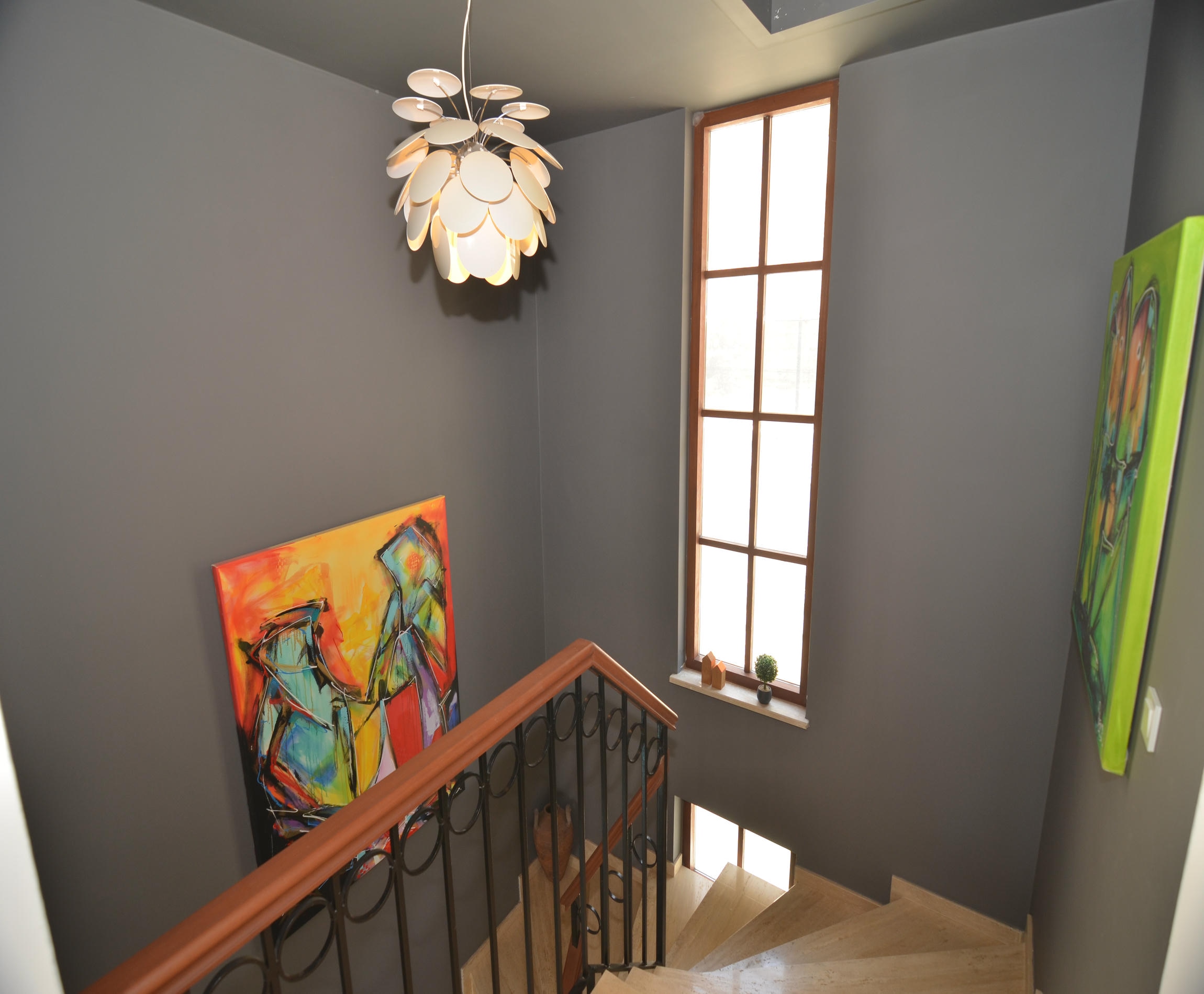 Staircase with stone steps, colorful artwork and potted plants in a villa