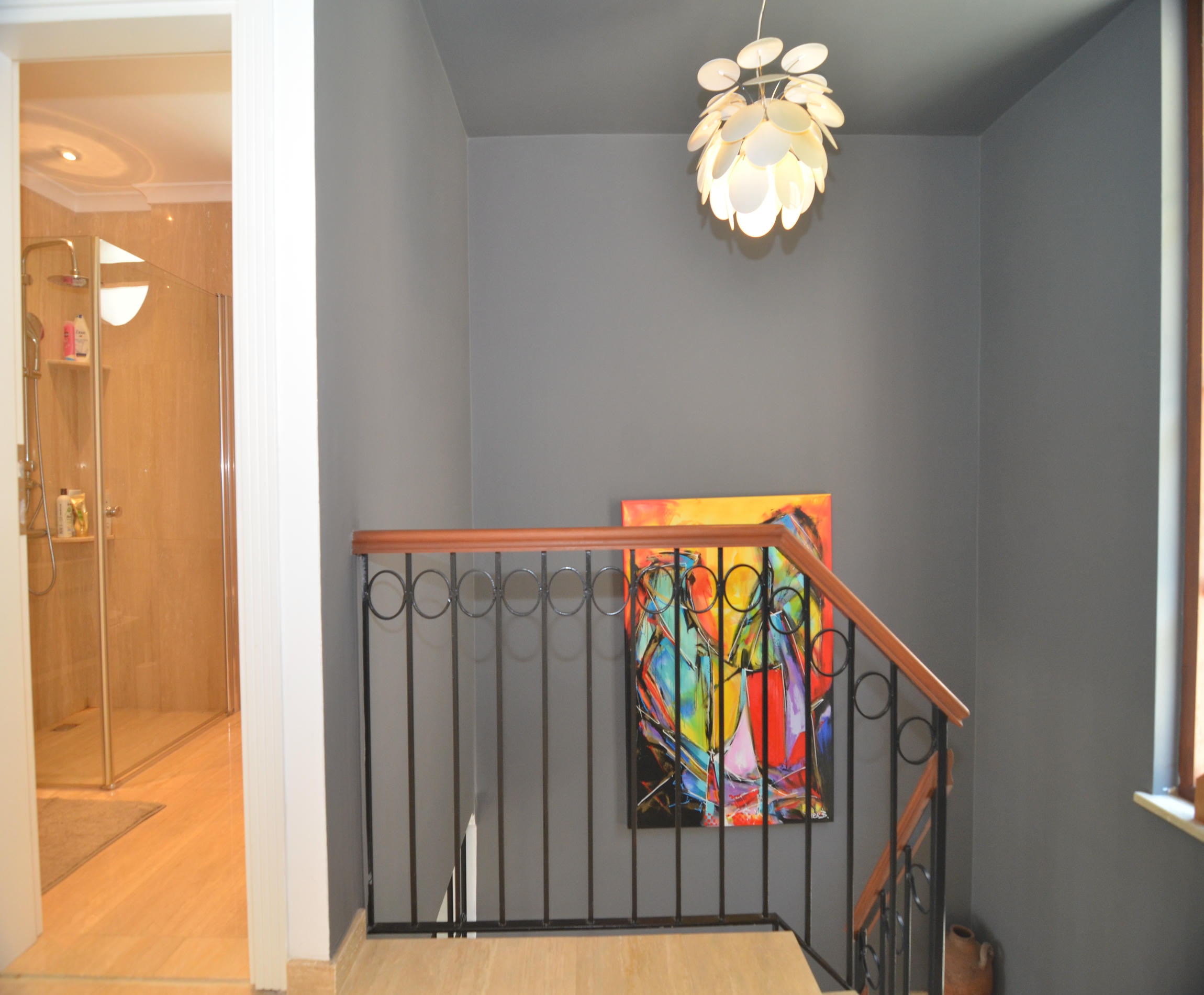 Staircase with wrought-iron railing and open bathroom door in an Alanya villa
