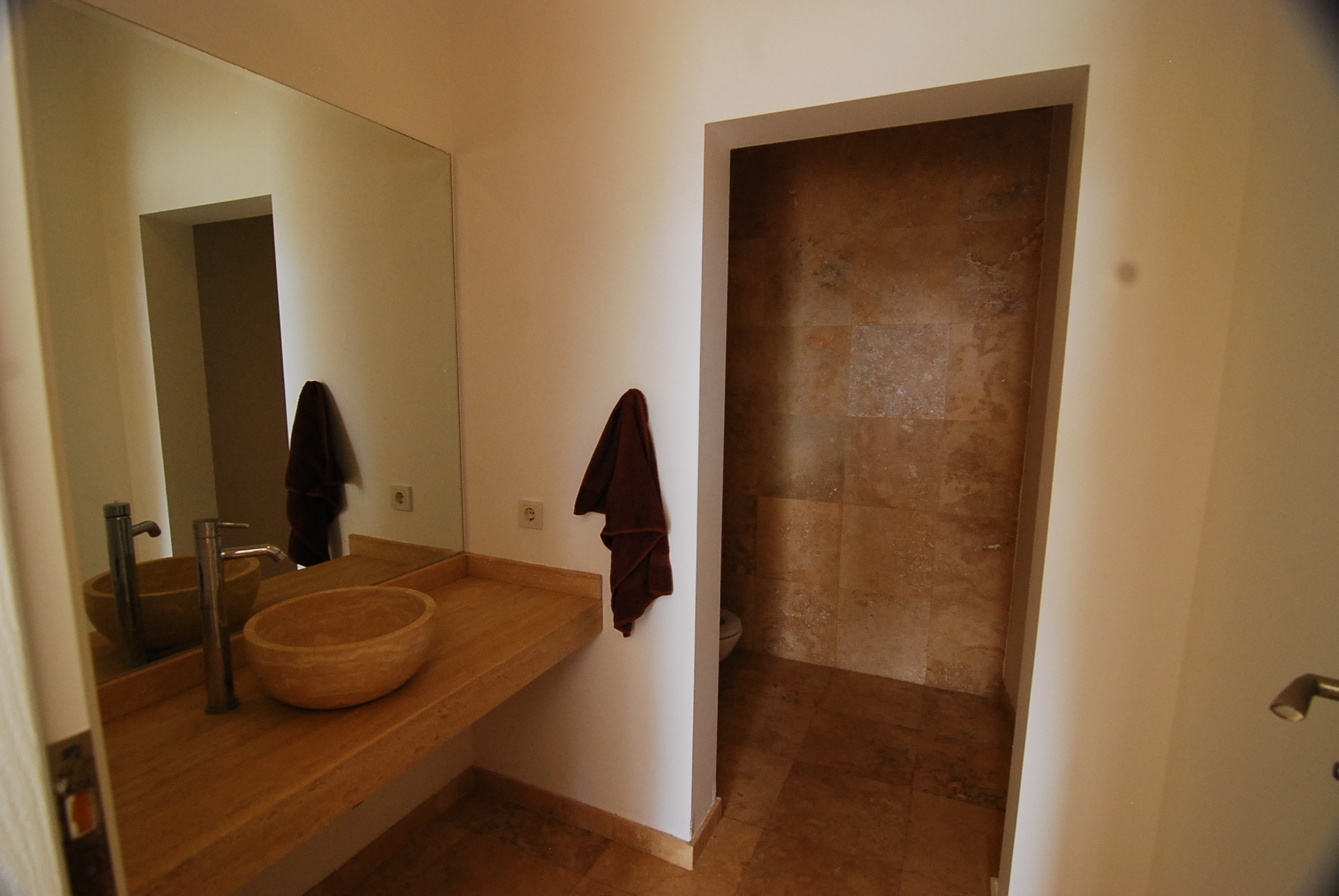 Bathroom with a wooden worktop, vessel sink and open shower in an Alanya house