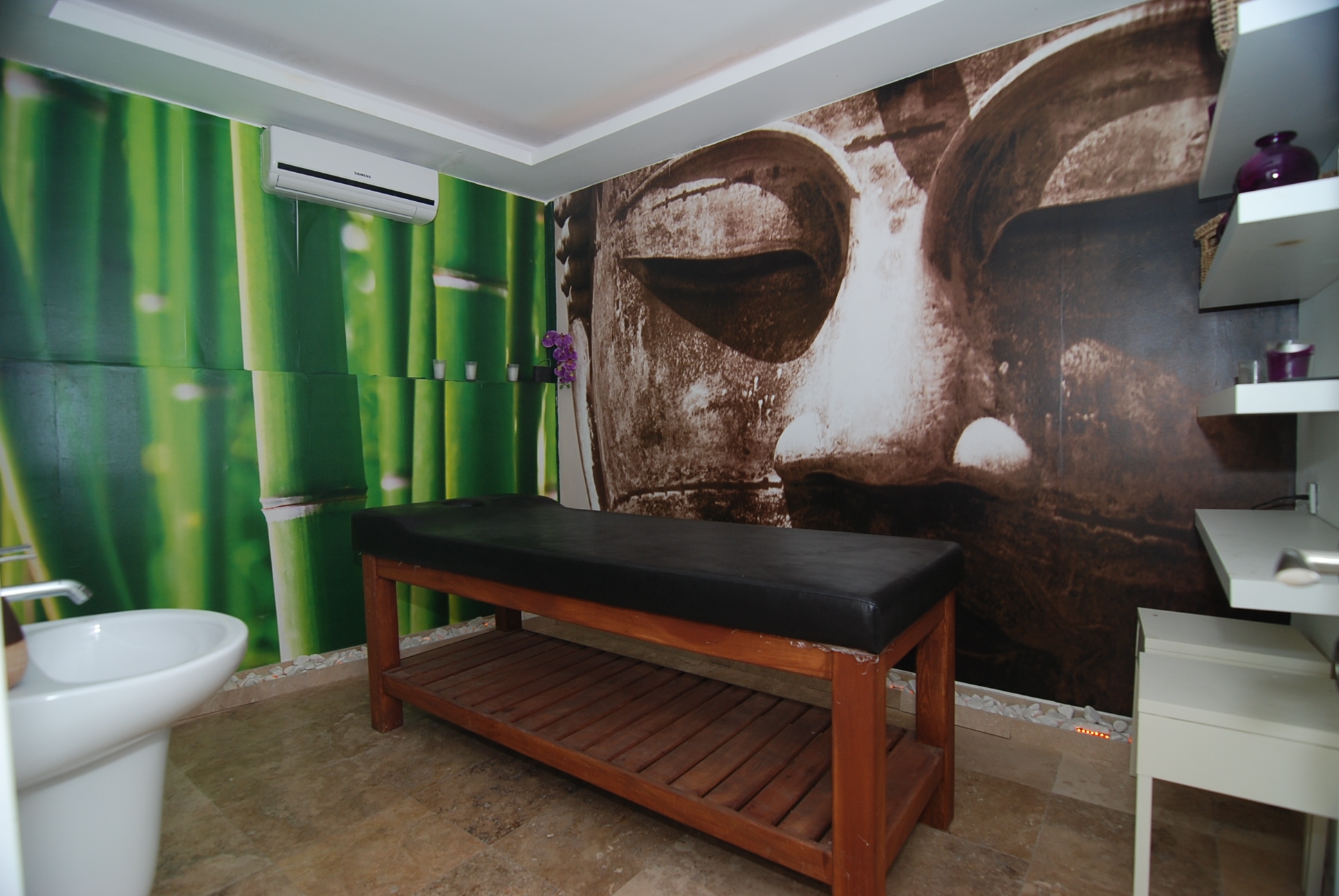 Spa area with a massage table and bowl sink in a complex with villas in Alanya