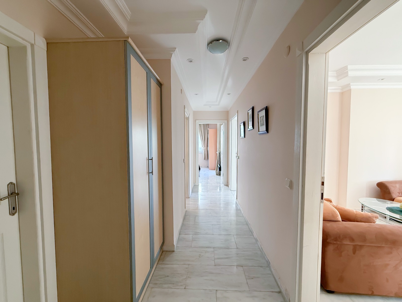 Walk-in wardrobe with a frosted closet and orange chair in Mahmutlar