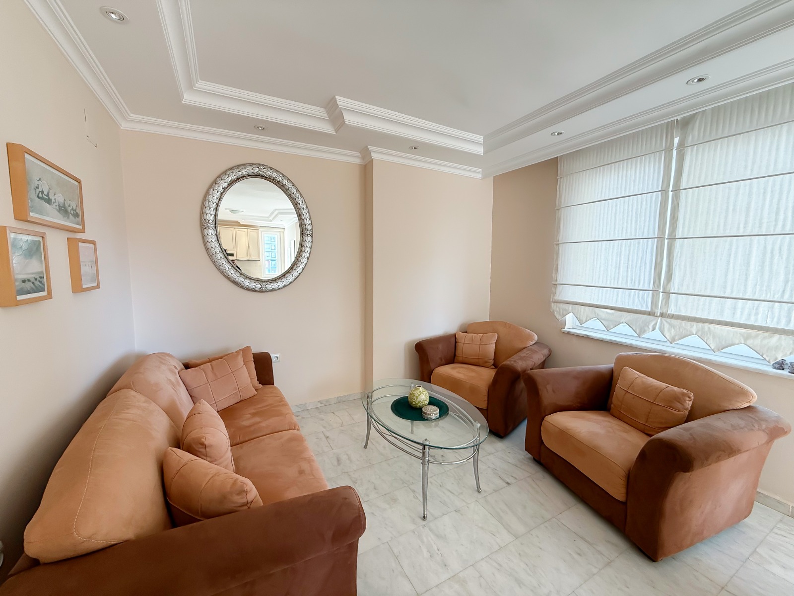 Living room with brown sofas and armchairs in an apartment for sale