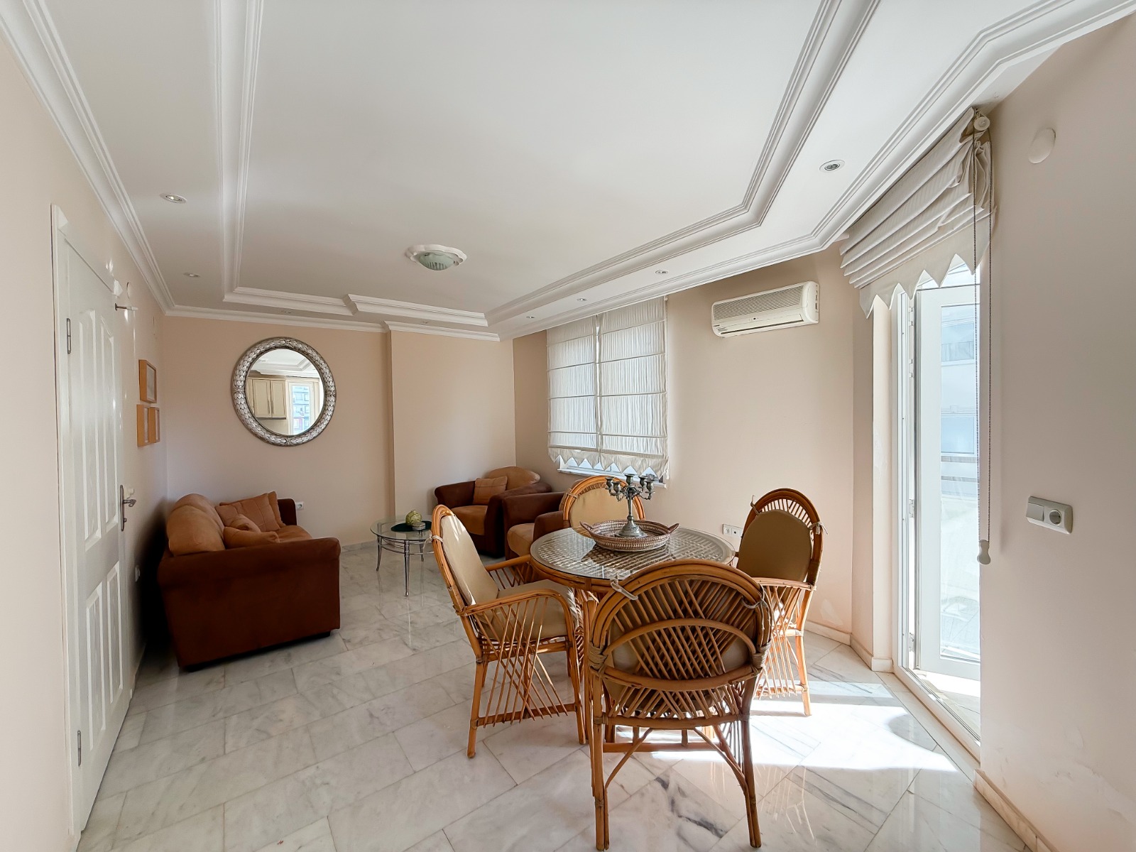 Kitchen-living room with soft seating and a glass balcony door in a flat in Mahmutlar