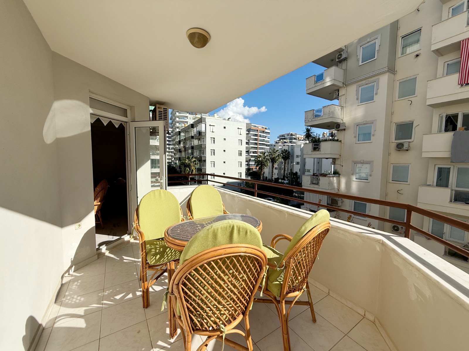 Covered terrace with a glass table and four chairs at a flat for sale in Mahmutlar