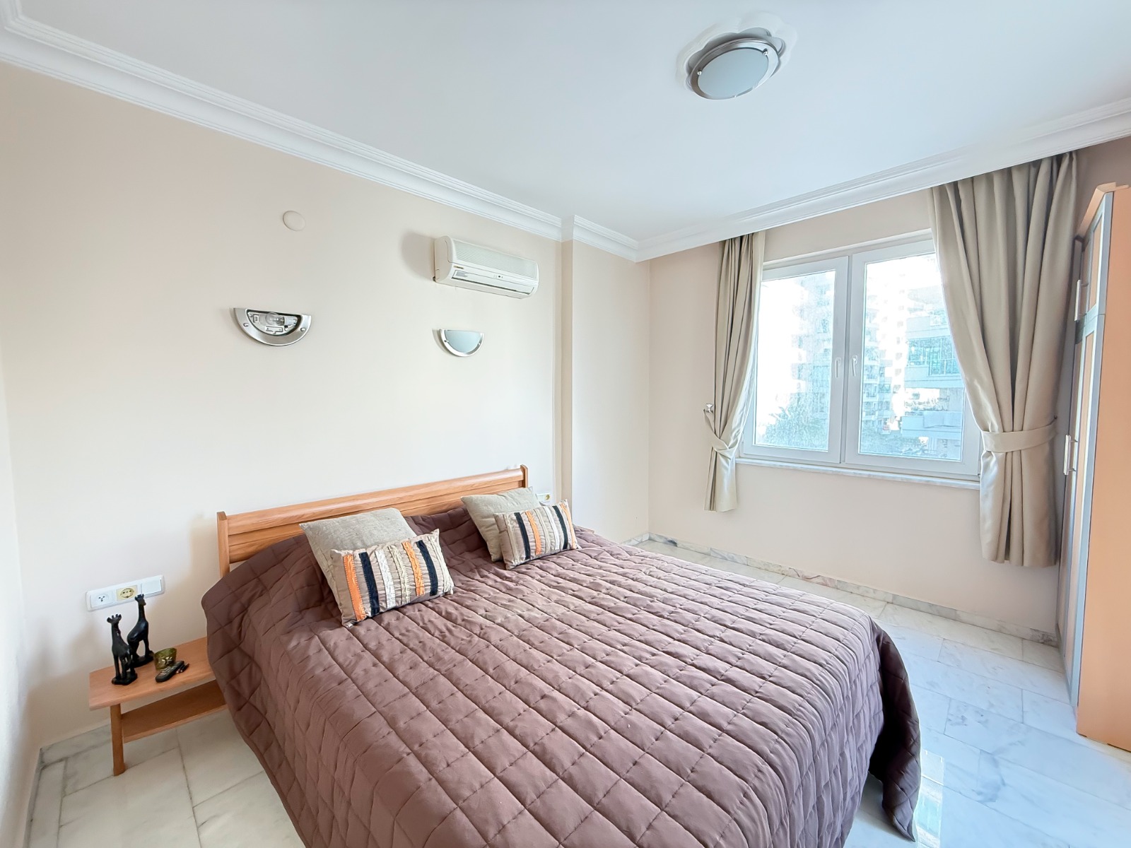 Bedroom with a double bed and panoramic window in an apartment in Mahmutlar