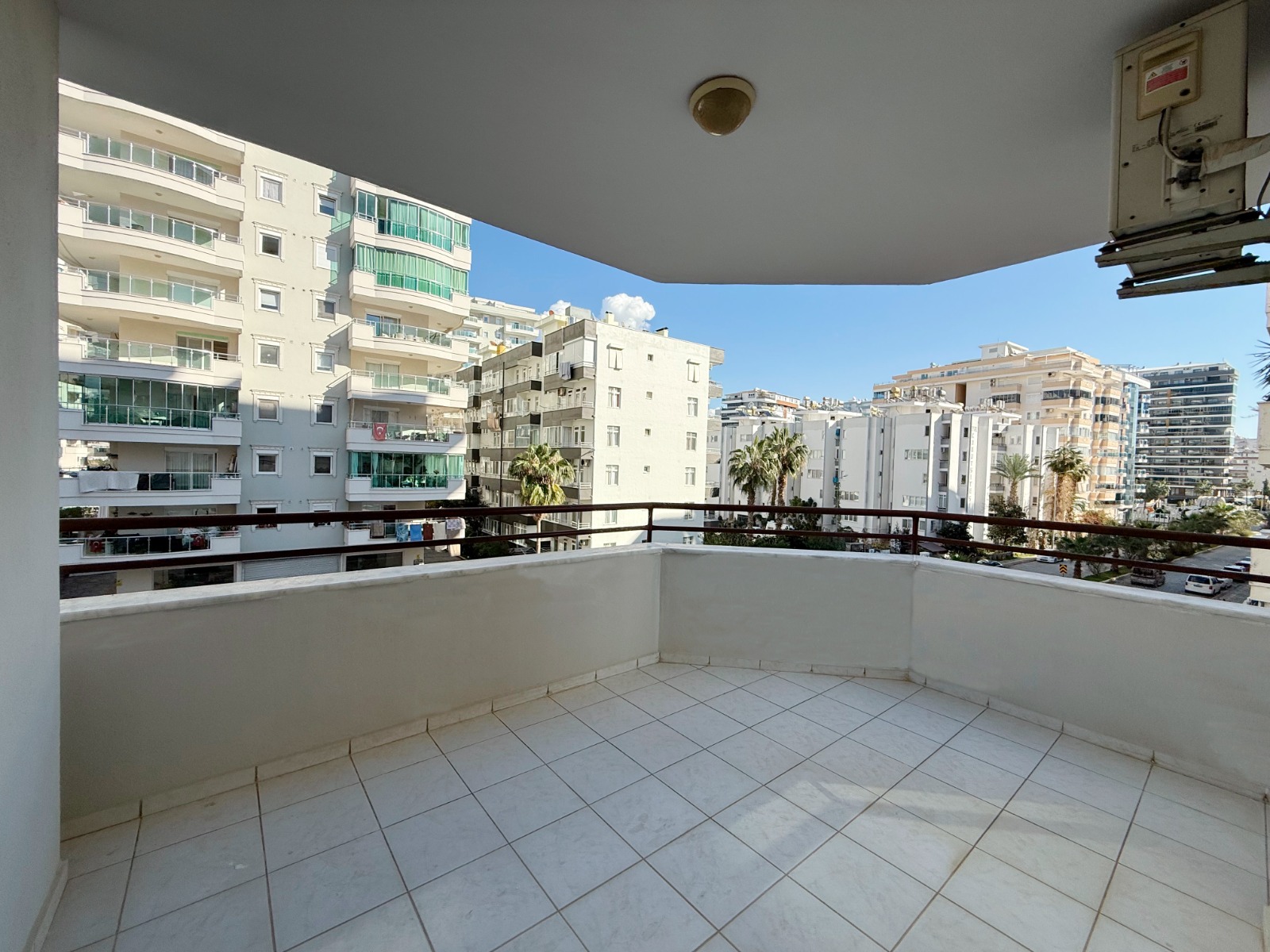 Balcony with a canopy and light tiles overlooking apartment buildings in Mahmutlar
