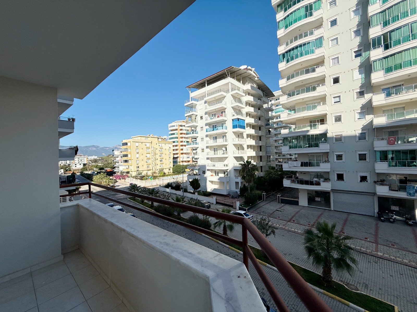 Corner terrace with marble railing and mountain view in a flat