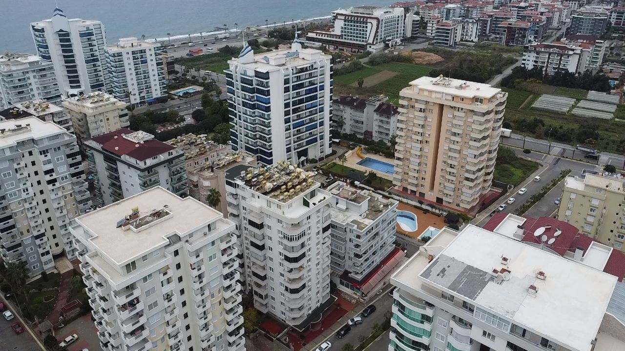 Balconied apartment buildings and a courtyard pool in a complex with apartments for sale in Turkey