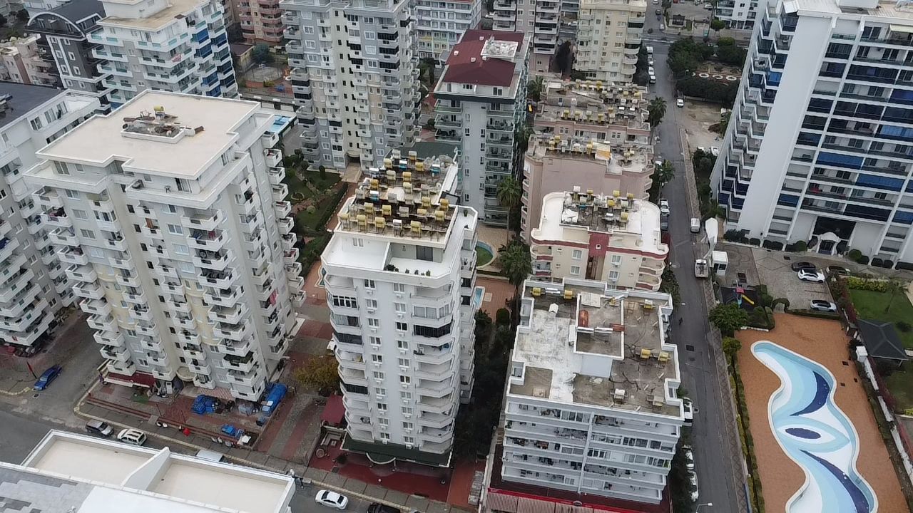 Aerial view of residential buildings and a winding pool in Mahmutlar where property is for sale