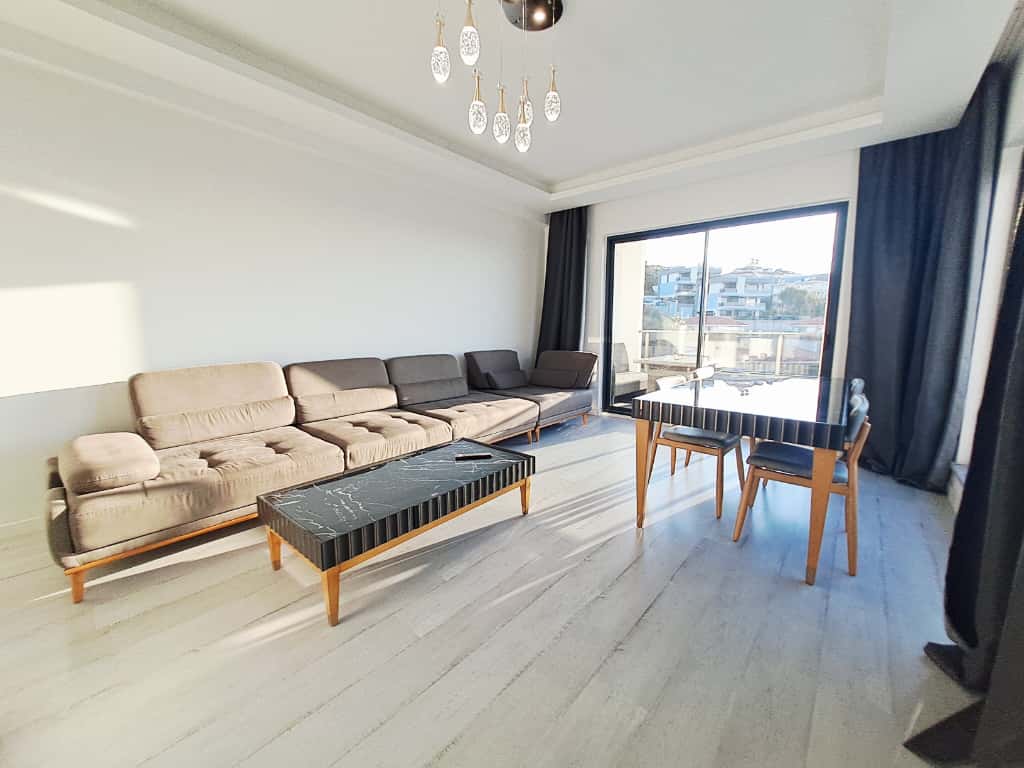 Oturma odasında uzun köşe koltuk ve panoramik pencere Kargıcak’taki penthouse dairede