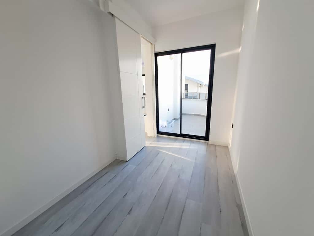 Yatak odasında gömme beyaz dolap ve balkona açılan sürgülü cam kapı Kargıcak’taki penthouse içinde