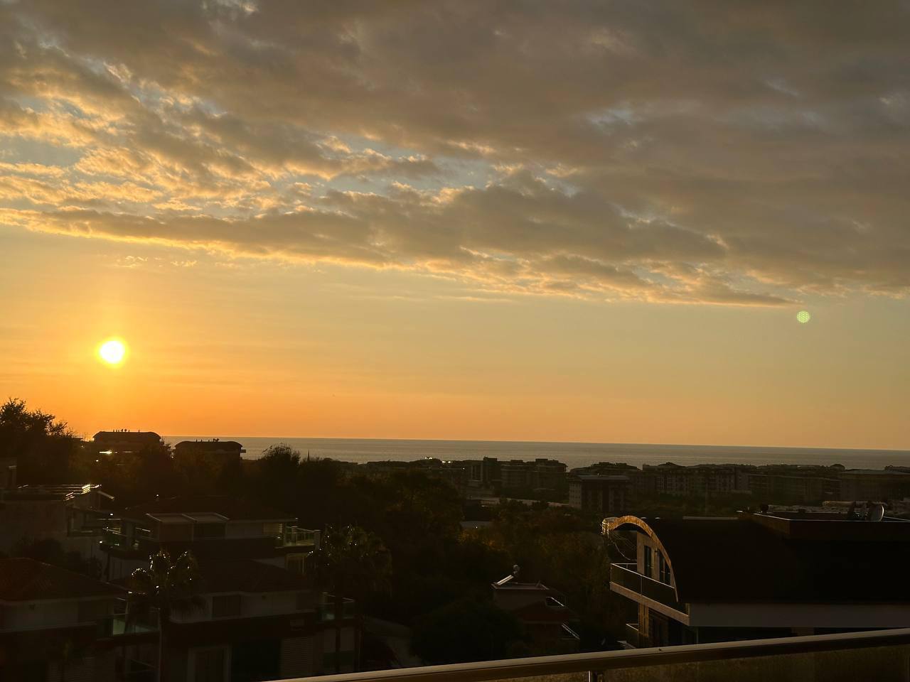 Deniz ufku ve turuncu gün batımı satışta olan penthouse dairenin manzarasında birleşiyor
