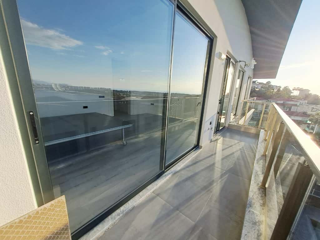 Balkonda uzun cam korkuluk ve dağlara bakan panoramik kapılar Kargıcak’ta Türkiye’deki rezidansta