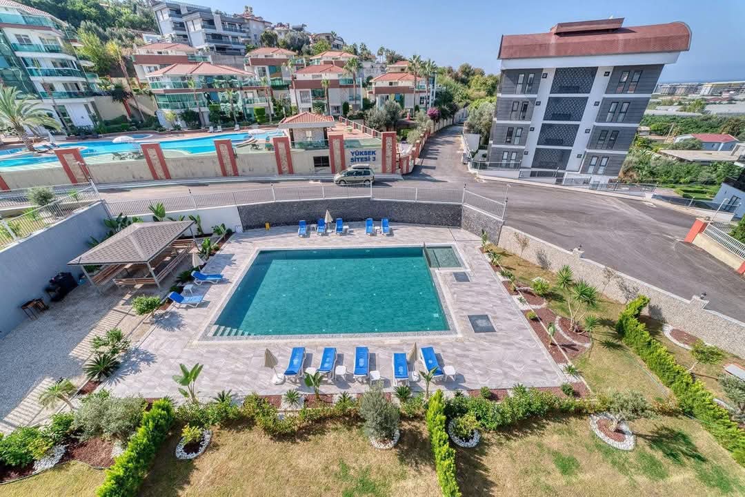 Open-air pool with loungers and a gazebo in a complex with residences for sale in Turkey