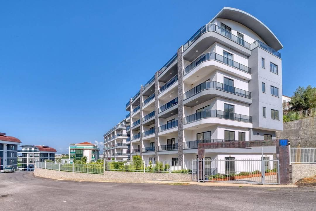 Curved-balcony facade of a top-floor apartment with a rounded roof in Kargicak