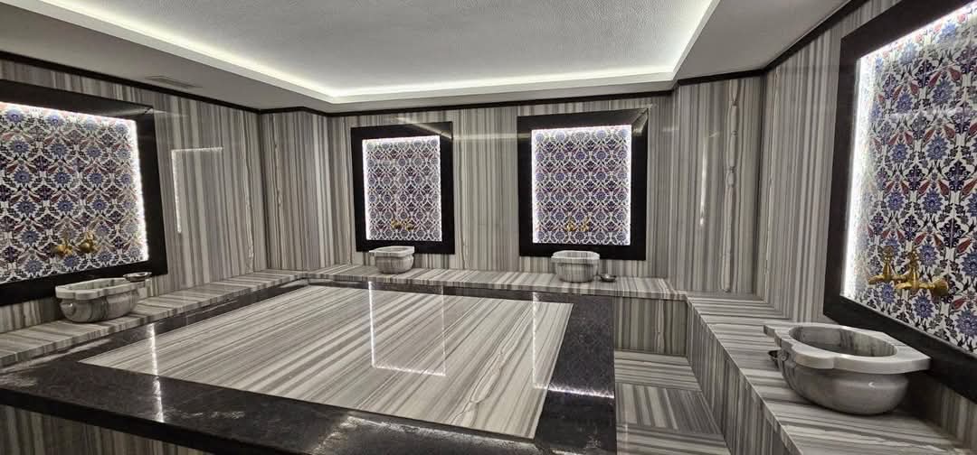 Hamamda merkezi mermer platform ve musluklu mermer kâseler çatı katı dairelerin kompleksinde