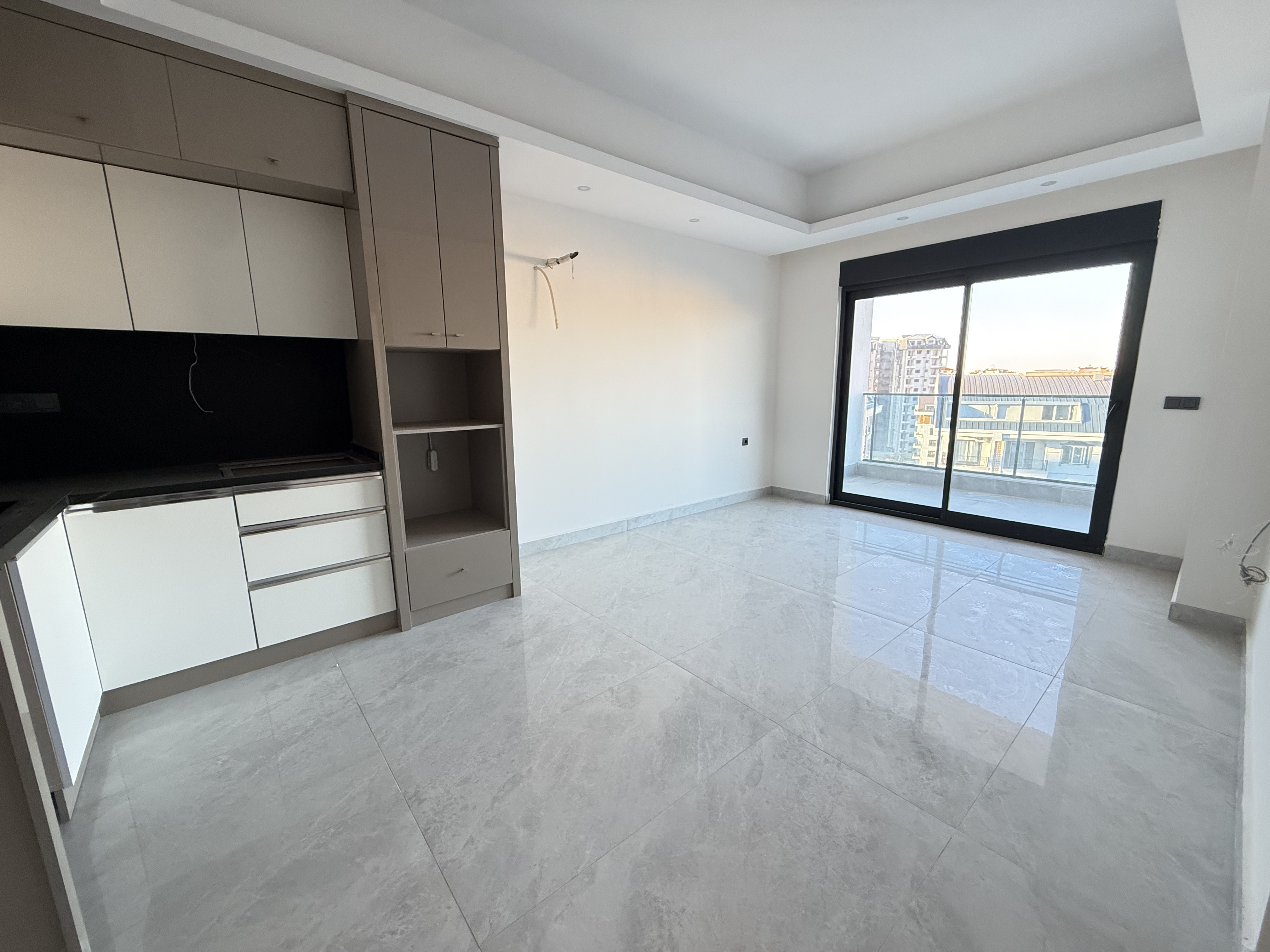 Kitchen-living room with fitted cabinets and a panoramic sliding window in an apartment