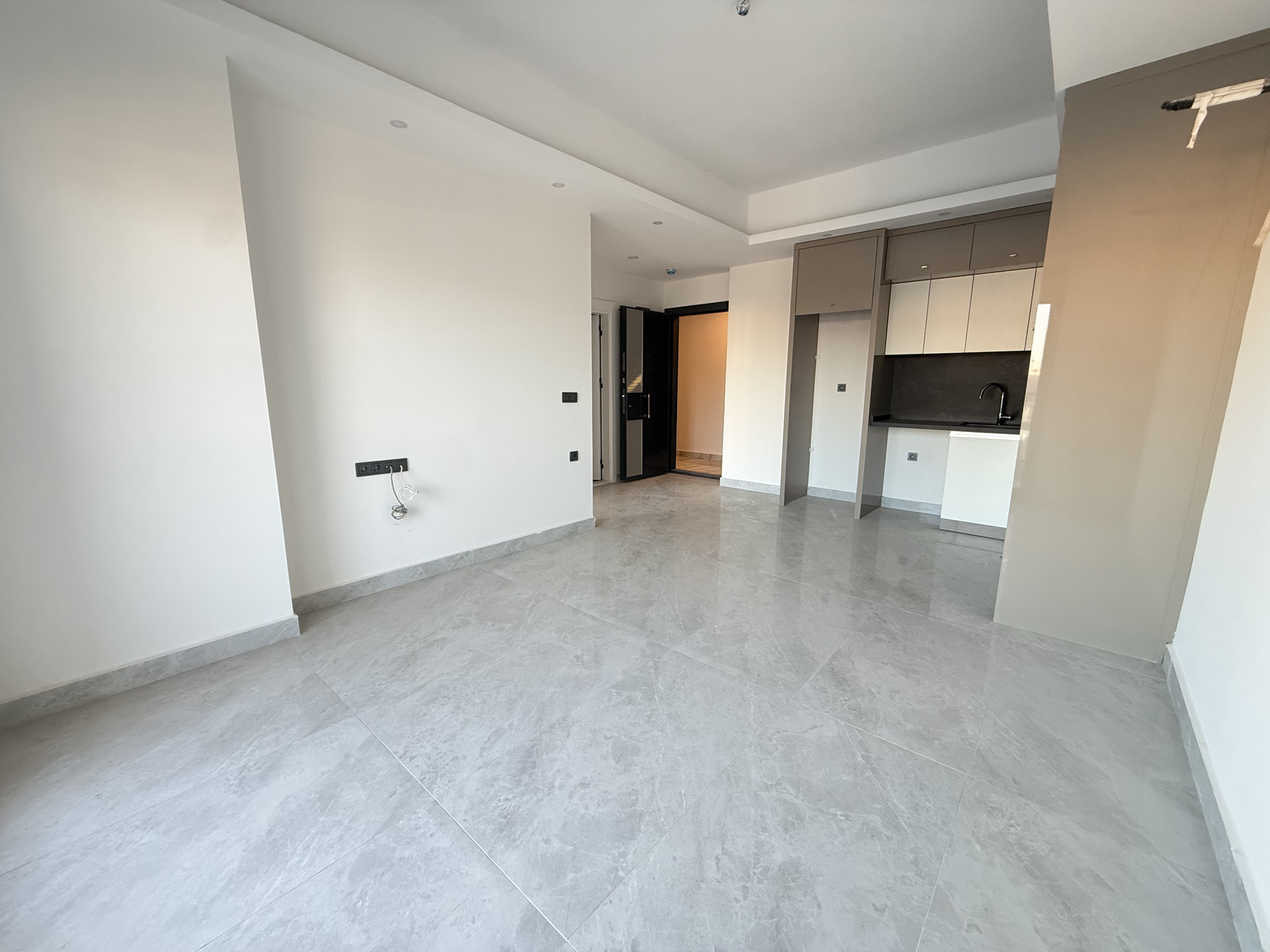 Kitchen-living room with a corner fitted cabinet and marble flooring in housing for sale in Turkey