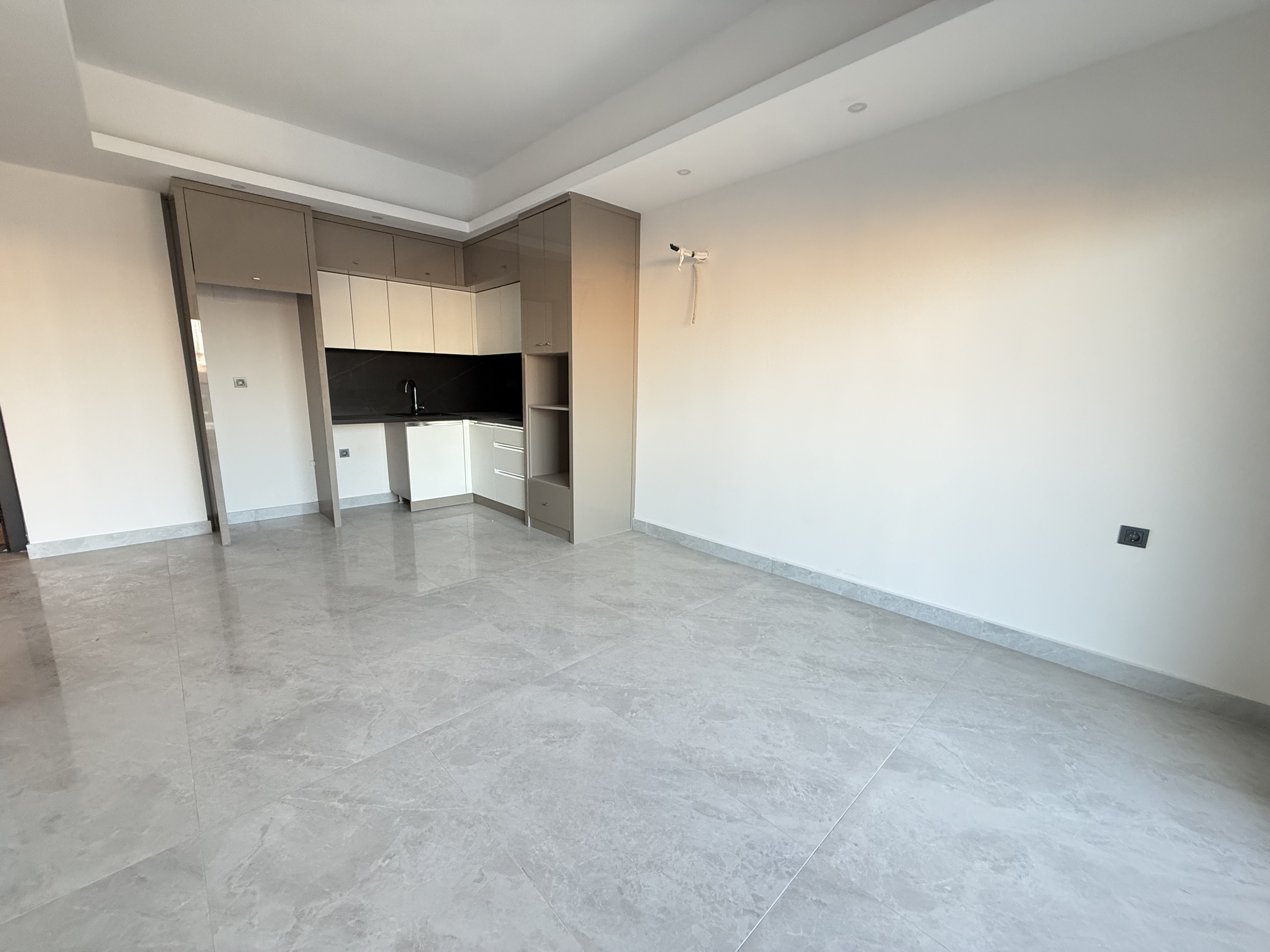 Kitchen-living room in an apartment for sale with a corner cabinet and spotlights