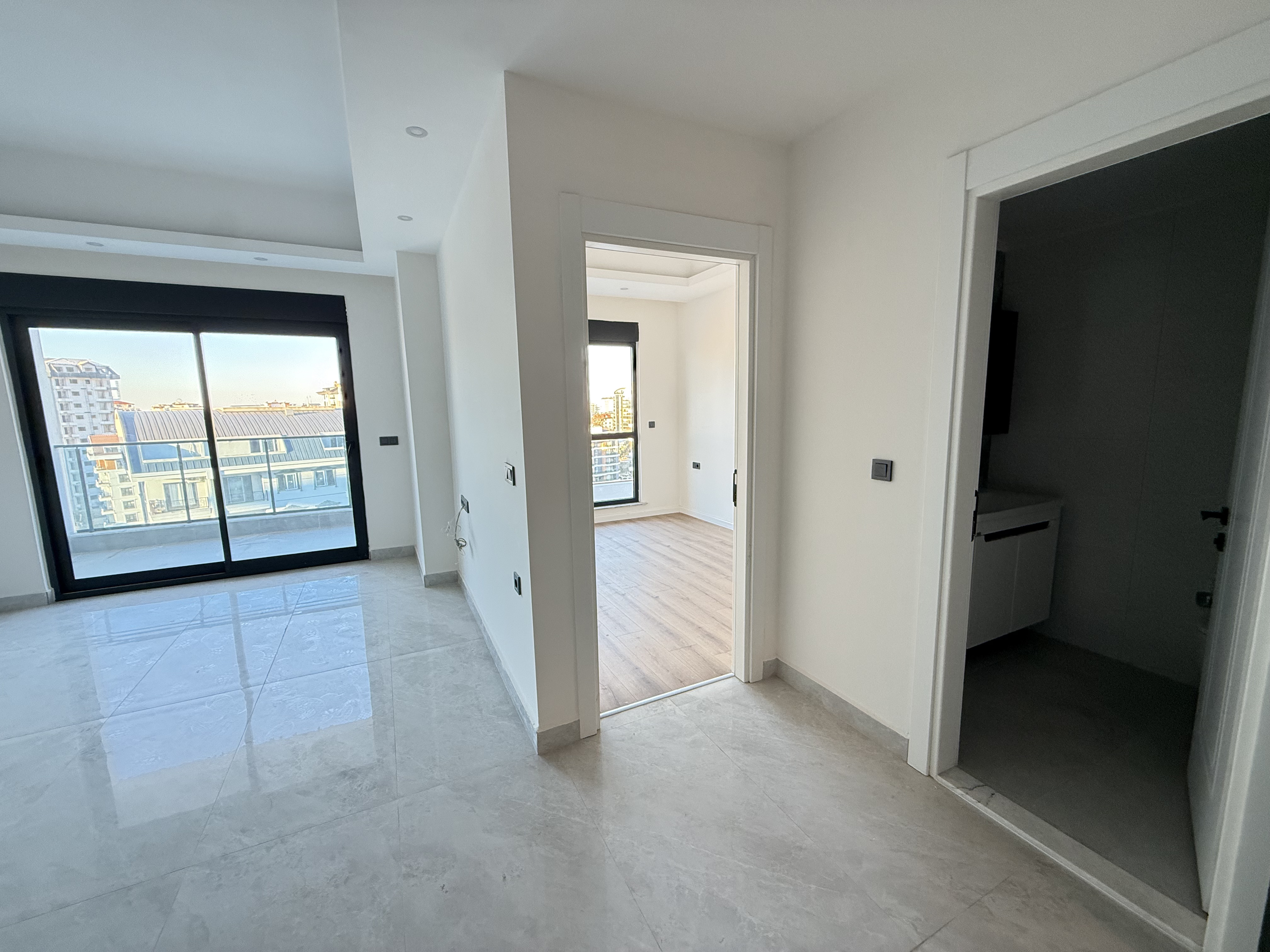 Kitchen-living room with a panoramic city window in an apartment in Mahmutlar