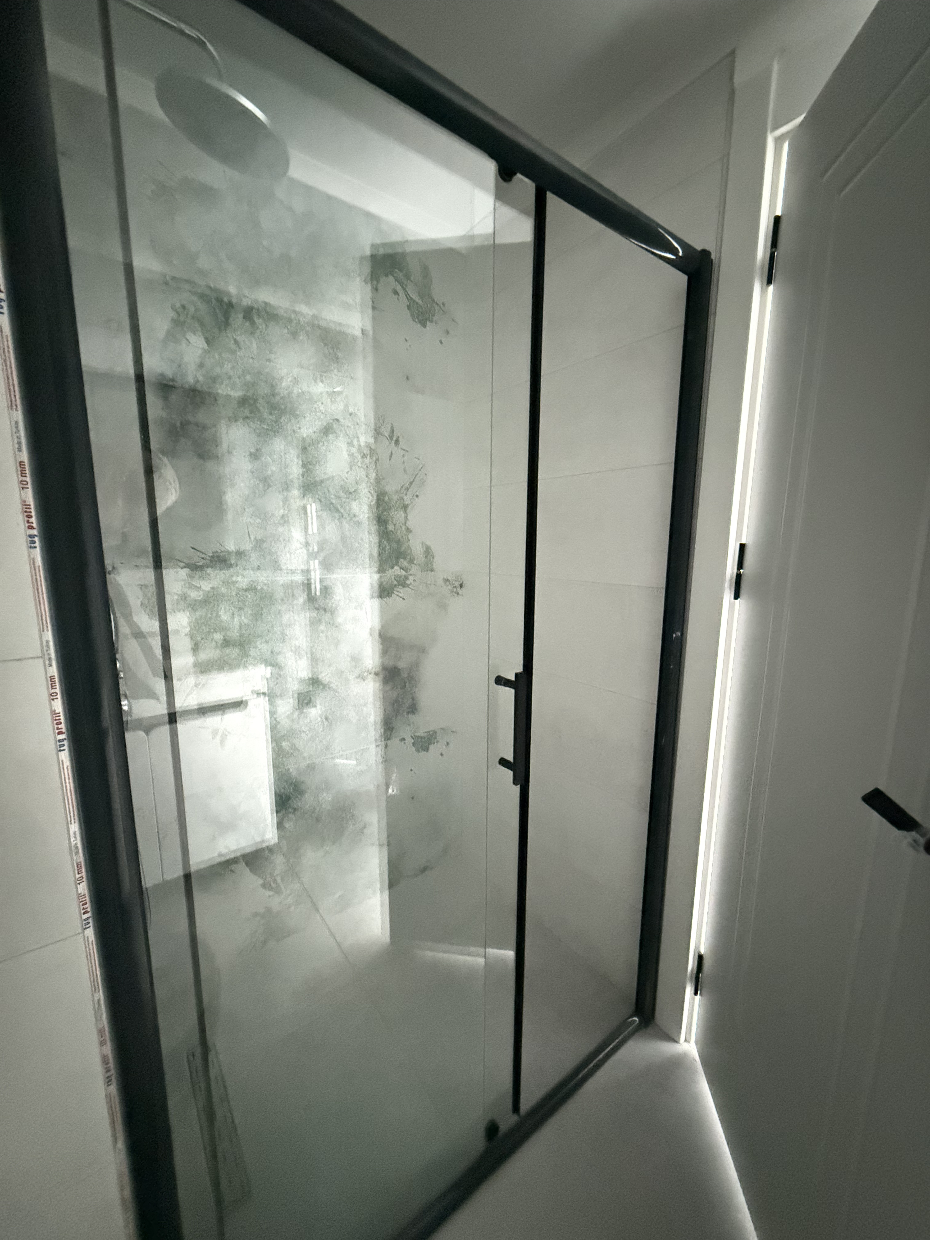 Bathroom with a glass shower enclosure and light wall tiles