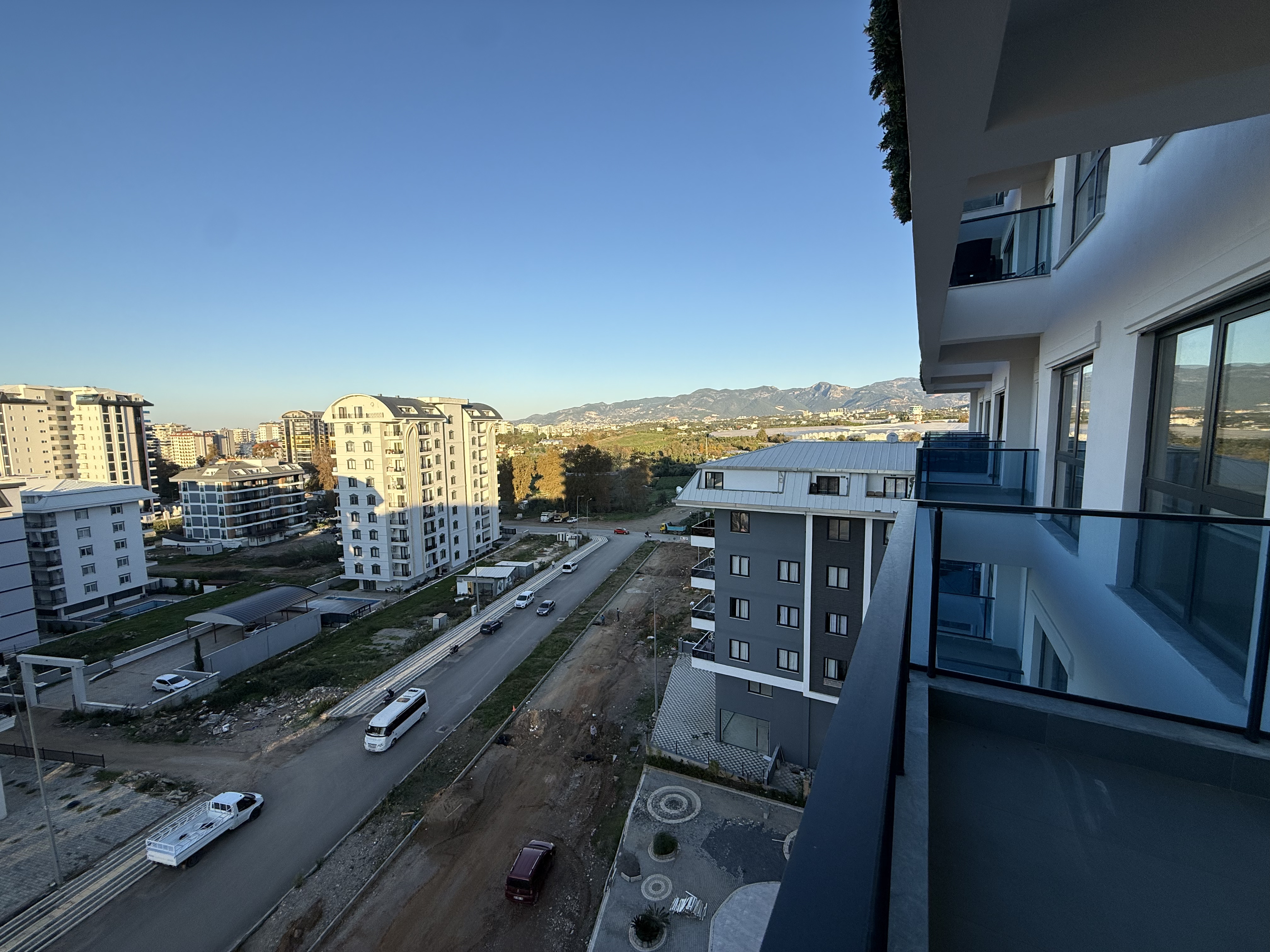 Balcony with a glass railing, city buildings and a mountain ridge in an apartment