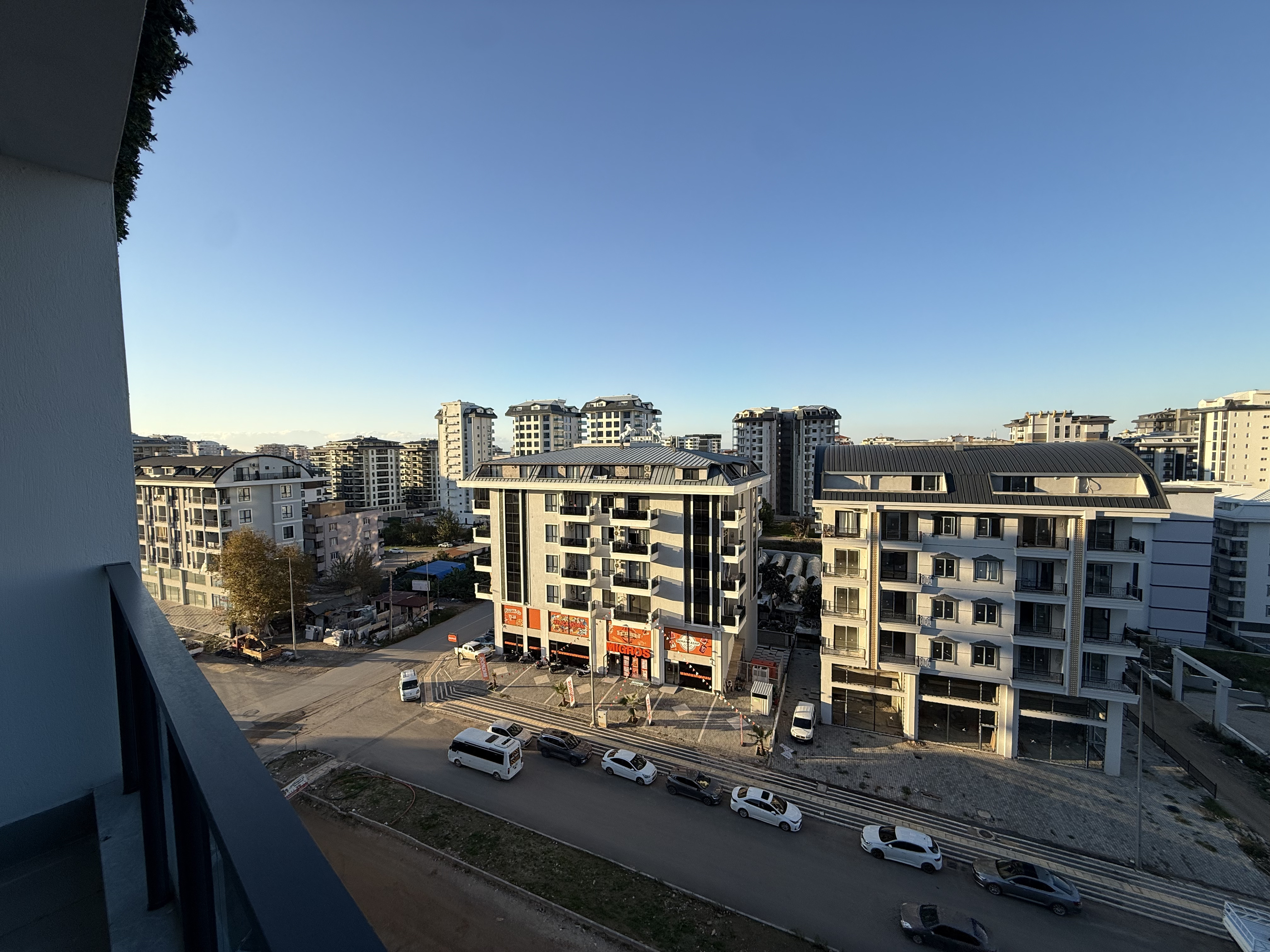 Balcony with a glass railing and city street in an apartment for sale in Turkey