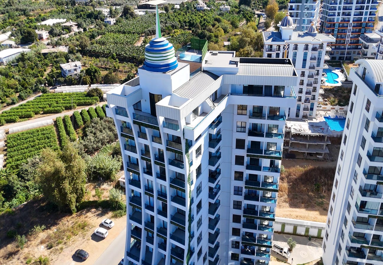 Multi-storey building with glass balconies and a roof dome for apartments for sale in Turkey