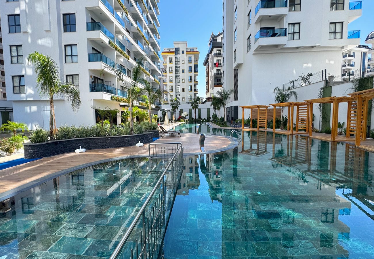 Turquoise pool with wooden pergolas for residents of apartments in Turkey