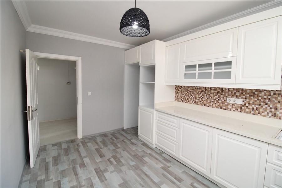 Camlı beyaz dolaplı mutfak mozaik tezgâh arasıyla 2+1 dairede