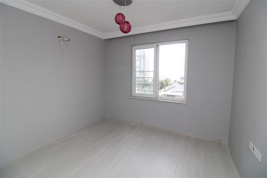 Panoramik pencereli boş yatak odası üç kırmızı abajurlu sarkıtla 2+1 dairede