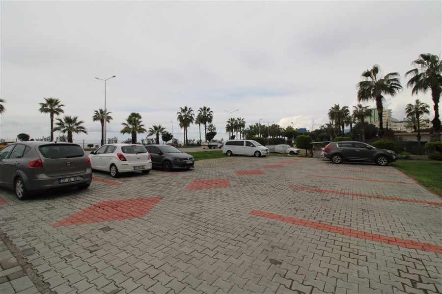 Palmiyeli açık otopark Mahmutlar'da dairelerin bulunduğu konut alanında deniz ufkuna bakıyor