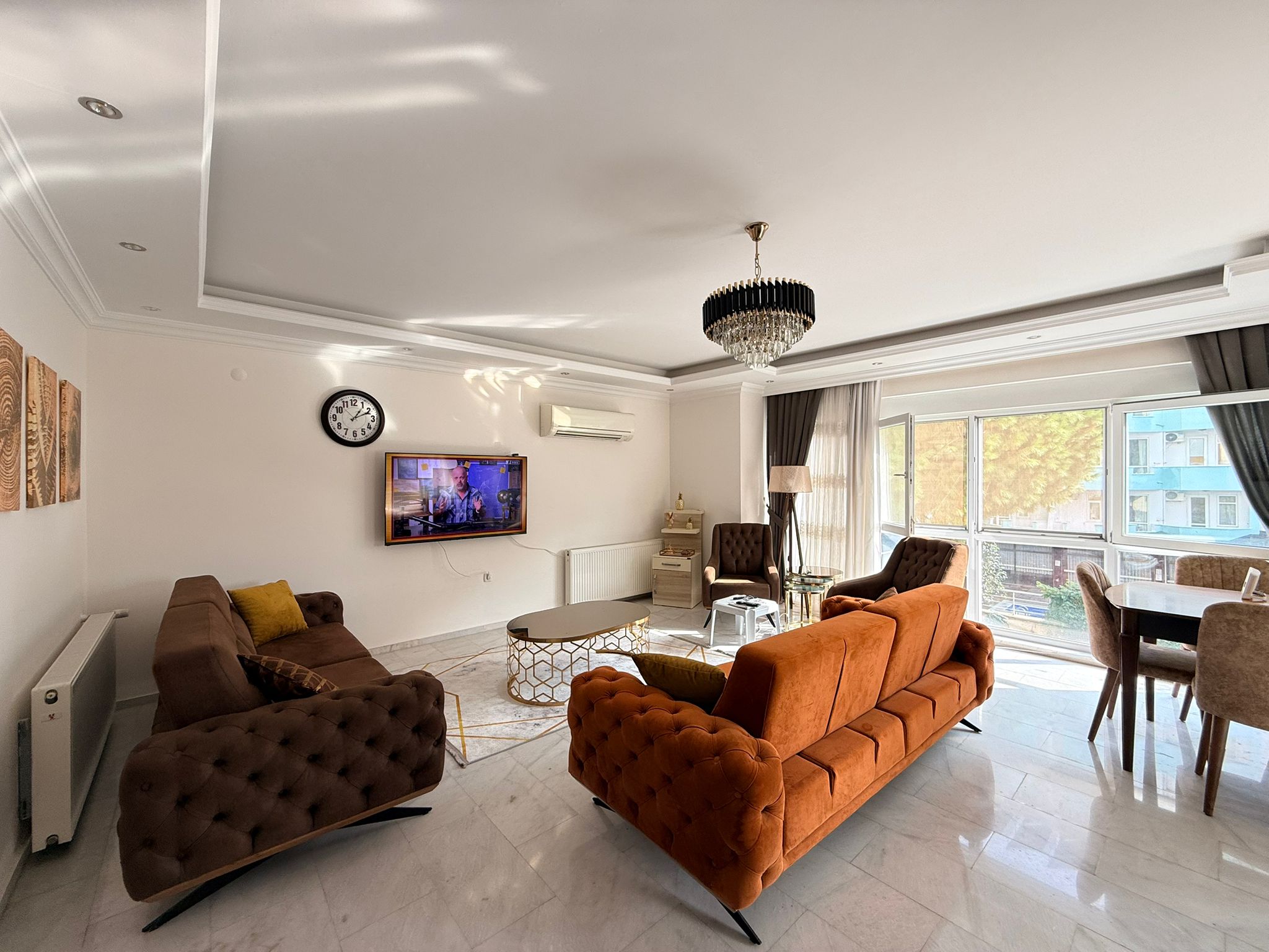 Turuncu köşe koltuklu salon, Türkiye'de satışta olan konutta panoramik camlarla aydınlanıyor
