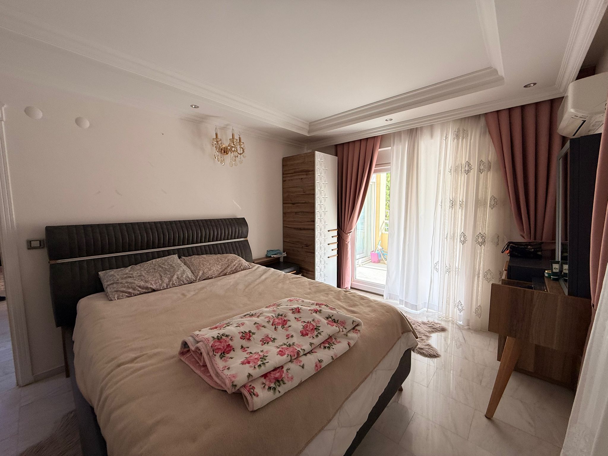 Mahmutlar'da çift kişilik yataklı yatak odası, ahşap dolap ve panoramik balkon kapısıyla