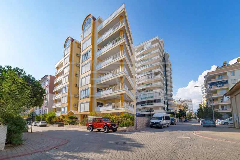 Sarı-bej cepheli, beyaz balkonlu bina: Mahmutlar, Alanya'da Türkiye'de satılık 3+1 daire — New Level Group
