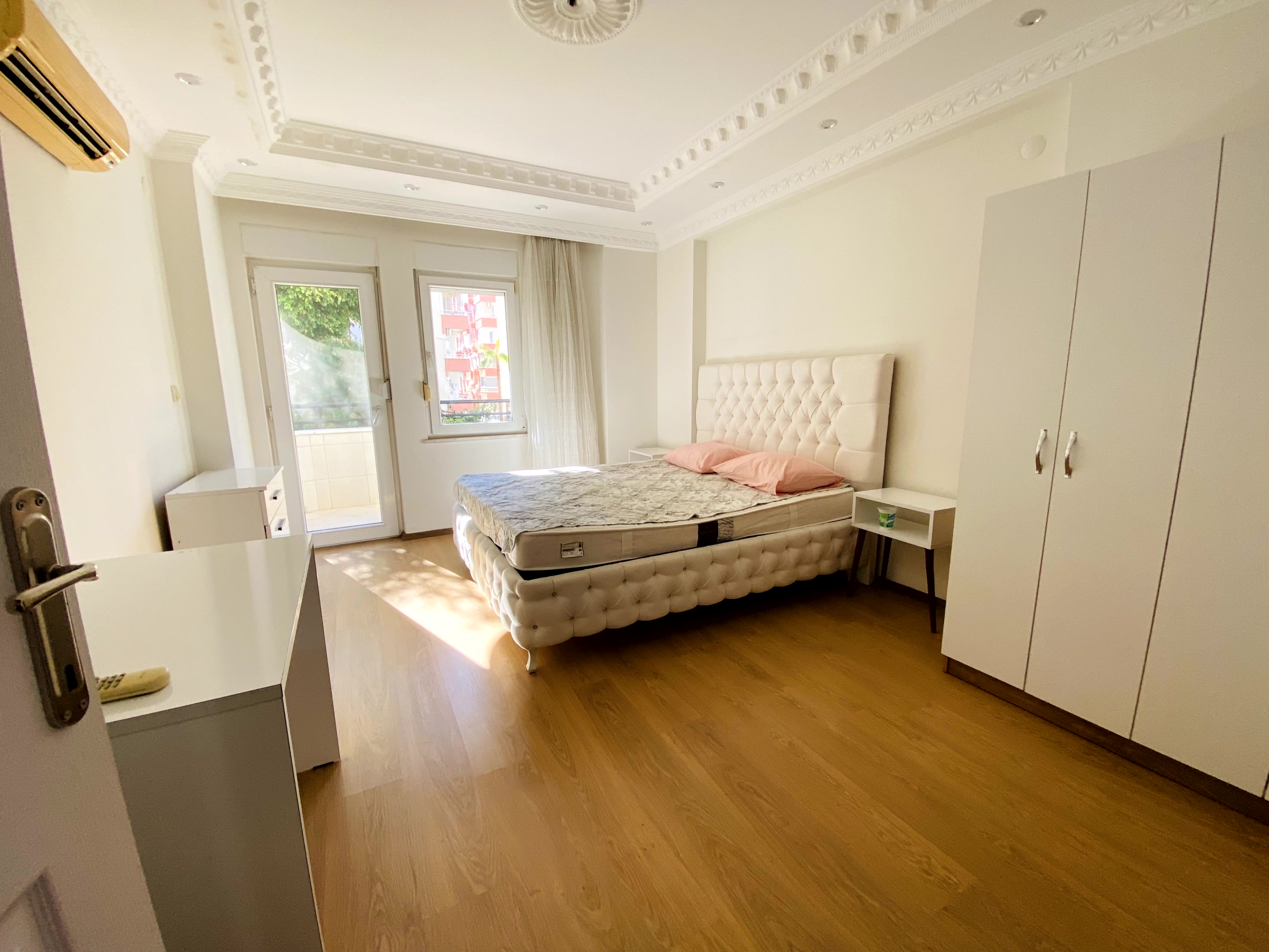 Yumuşak başlıklı çift kişilik yataklı yatak odası ve balkon kapısı bulunan daire