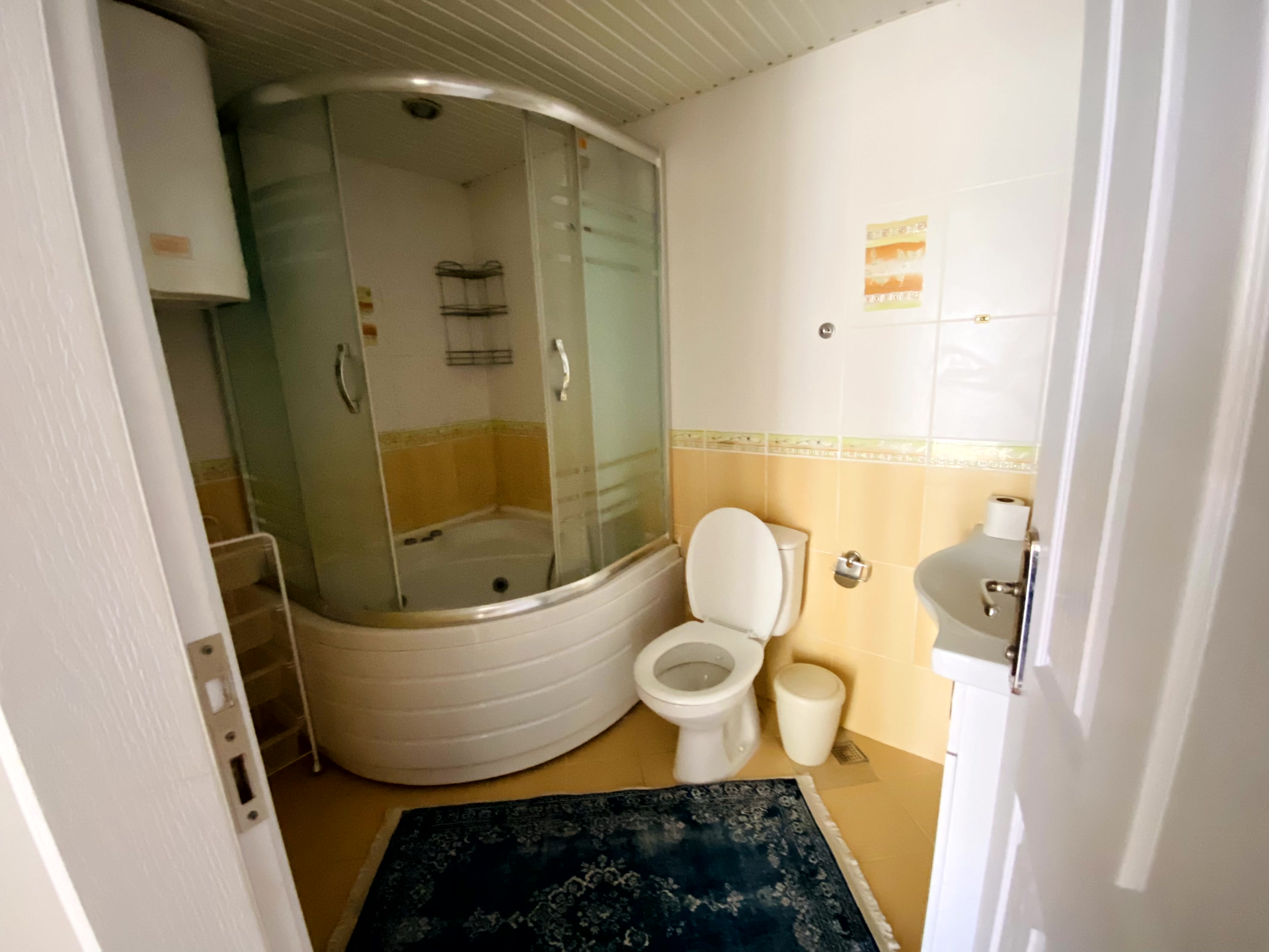 Köşe hidromasajlı küvet ve duş kabinli banyo dairede duvar tipi lavabo ile birlikte