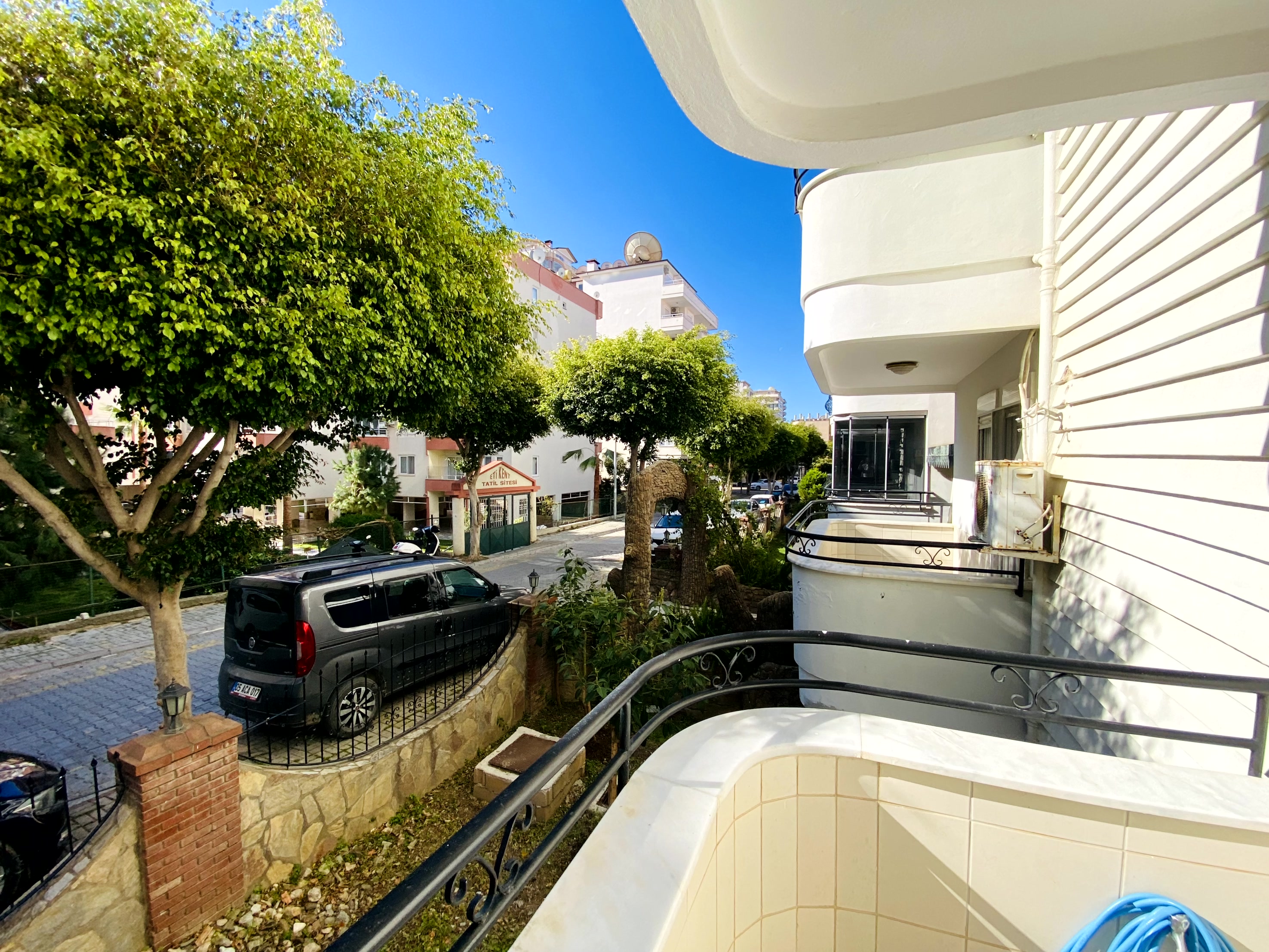 Ferforje balkon korkuluğu Mahmutlar’da satılık dairenin çevresindeki yuvarlak balkonlu cephelerle