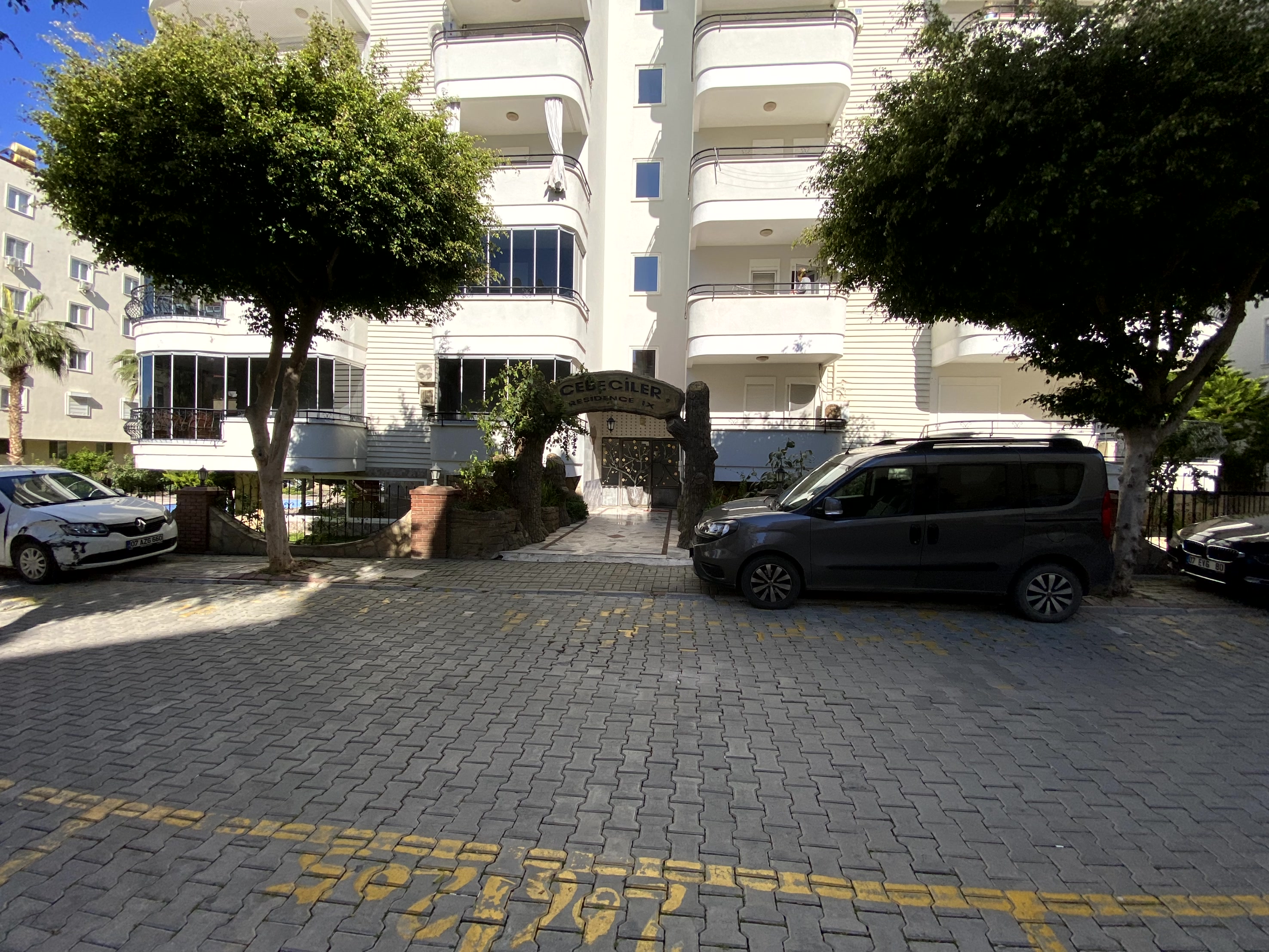 Giriş saçağı ve açık camlı balkonları görülen konut cephesinde Türkiye’de satılık daireler