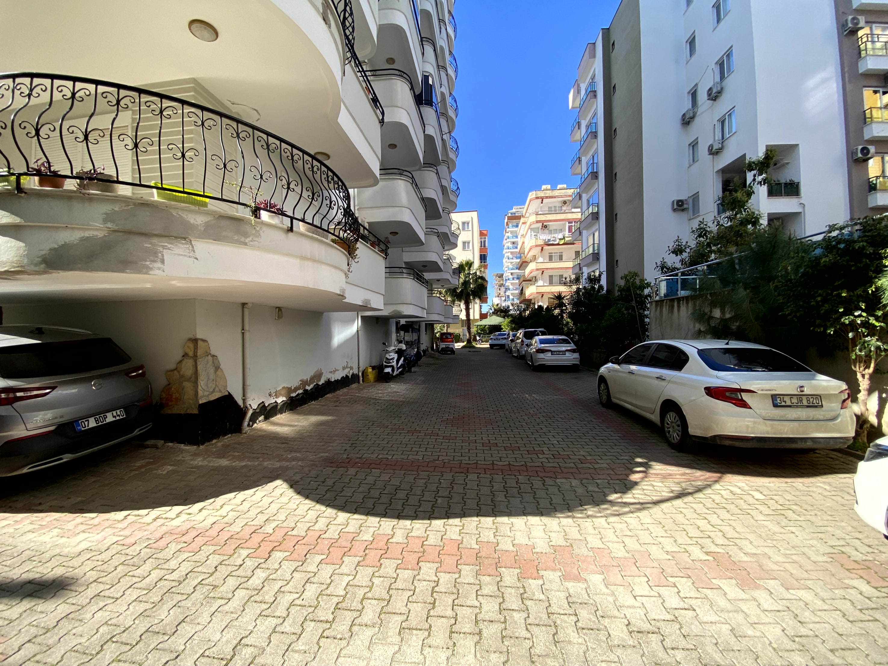 Ağaçlı taş döşeli iç yol ve karşılıklı apartmanlar Türkiye’deki konutların arasında