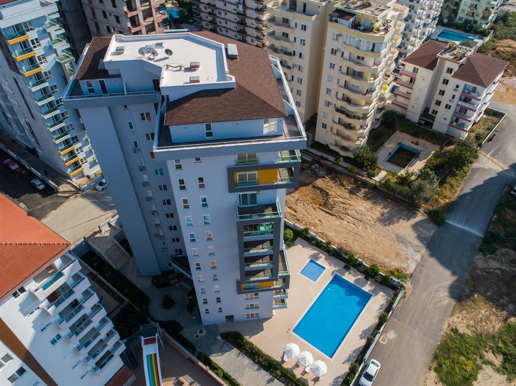 Açık havuzlu çok katlı daire kompleksi ve cam balkonlar Mahmutlar’da, Türkiye’de şehir yollarıyla çevrili