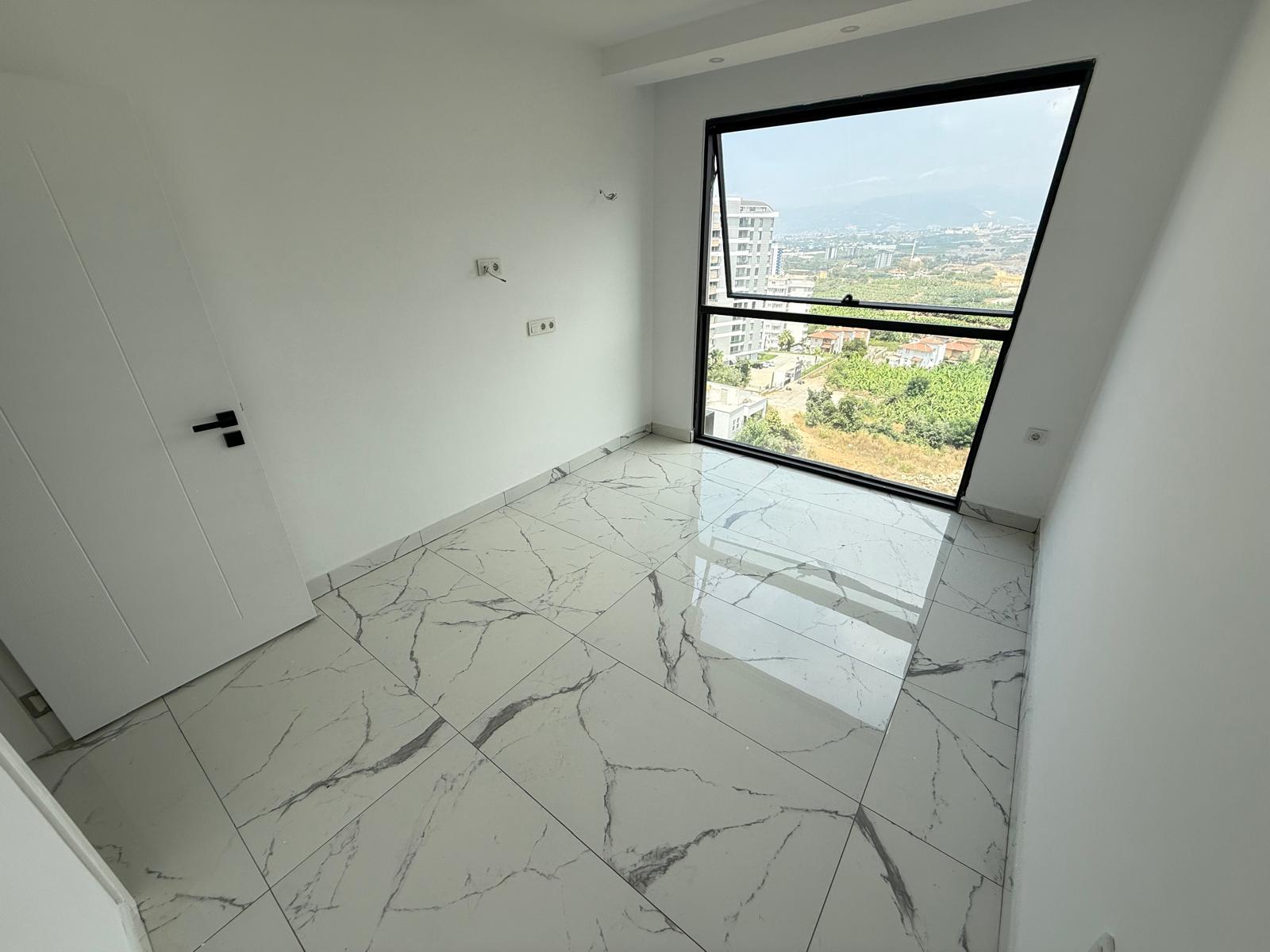 Bedroom with a panoramic sloped window overlooking the city and mountains in a flat