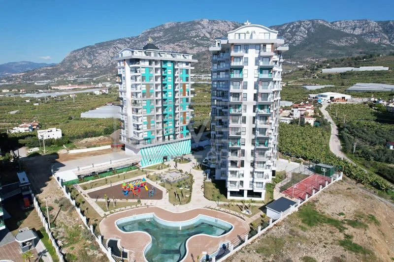 Aerial view of two residential buildings and a freeform pool in Mahmutlar where units are for sale