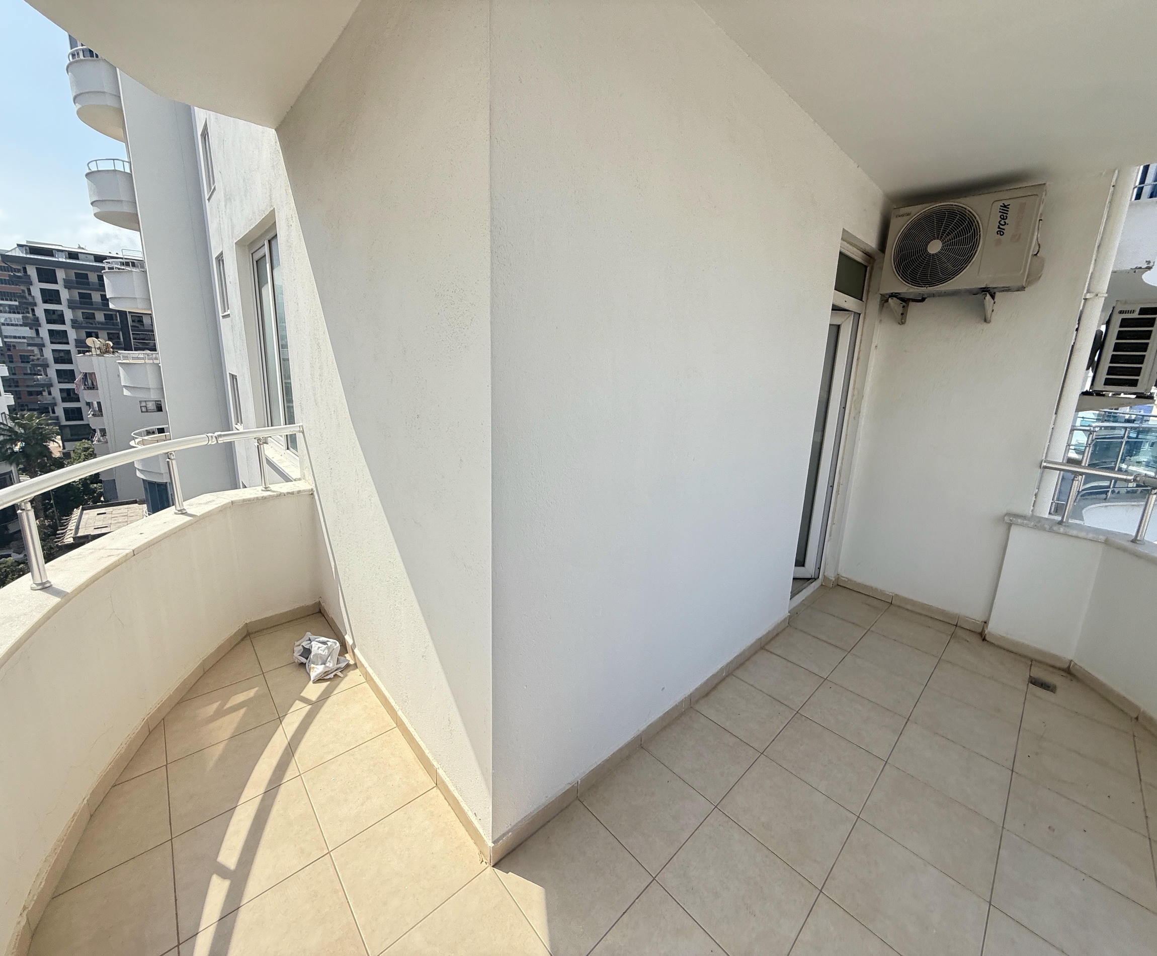 Türkiye’deki konutun köşe terasında karo zemin, metal korkuluk ve cam balkon kapısı görülüyor