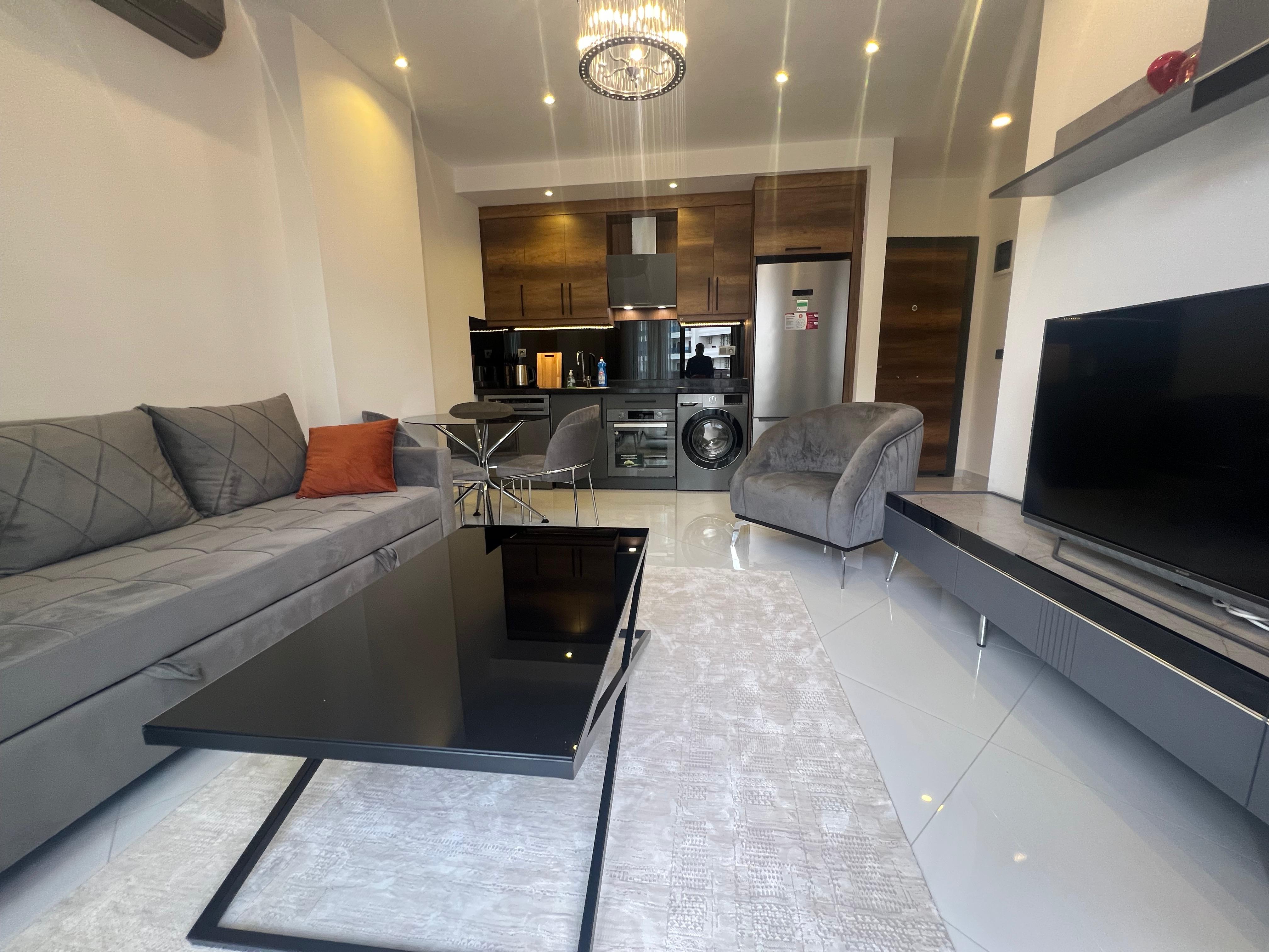 A gray corner sofa and wood-front cabinets in a home for sale