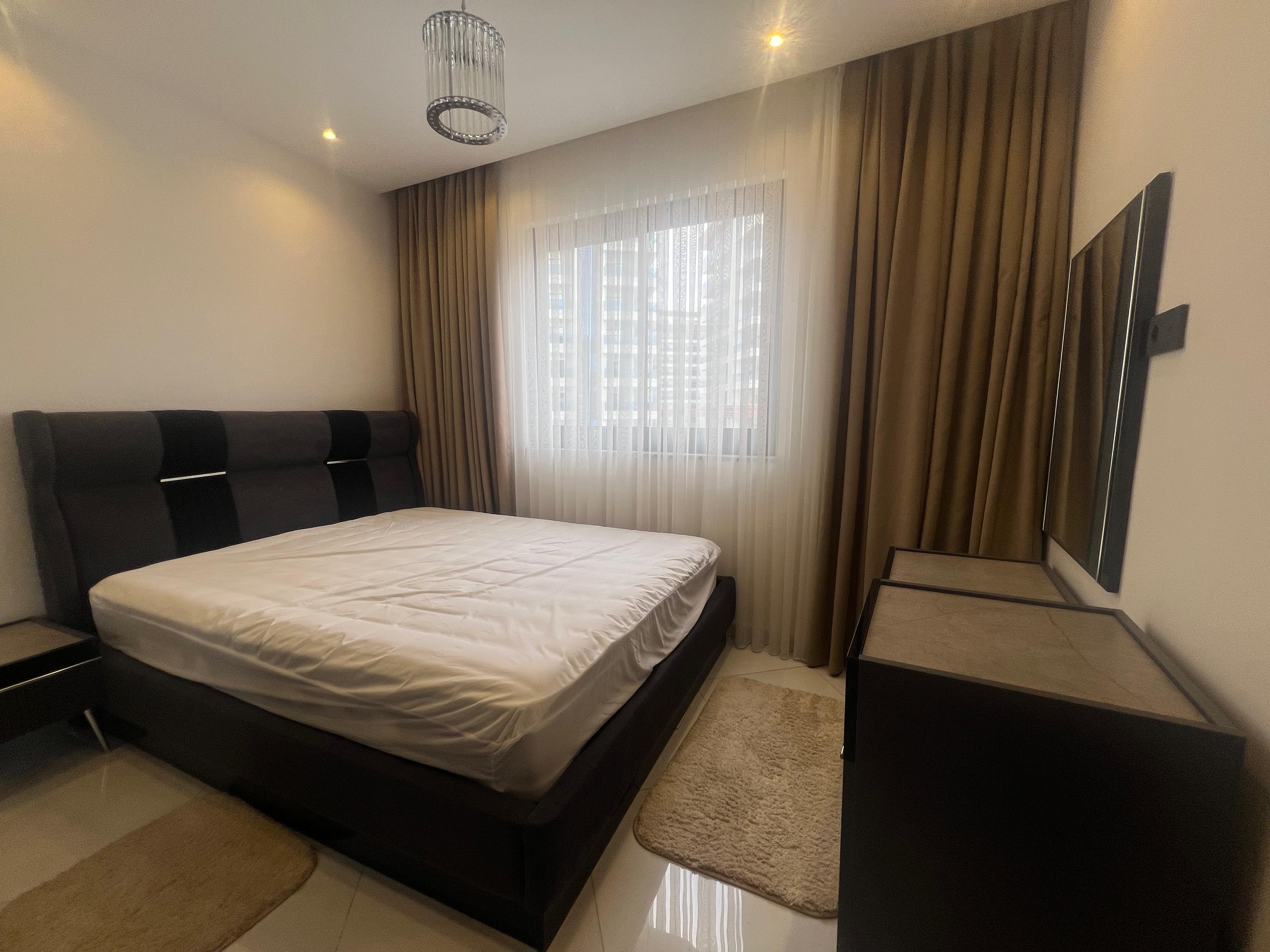 Padded headboard and sheer curtains in a bedroom inside a residence