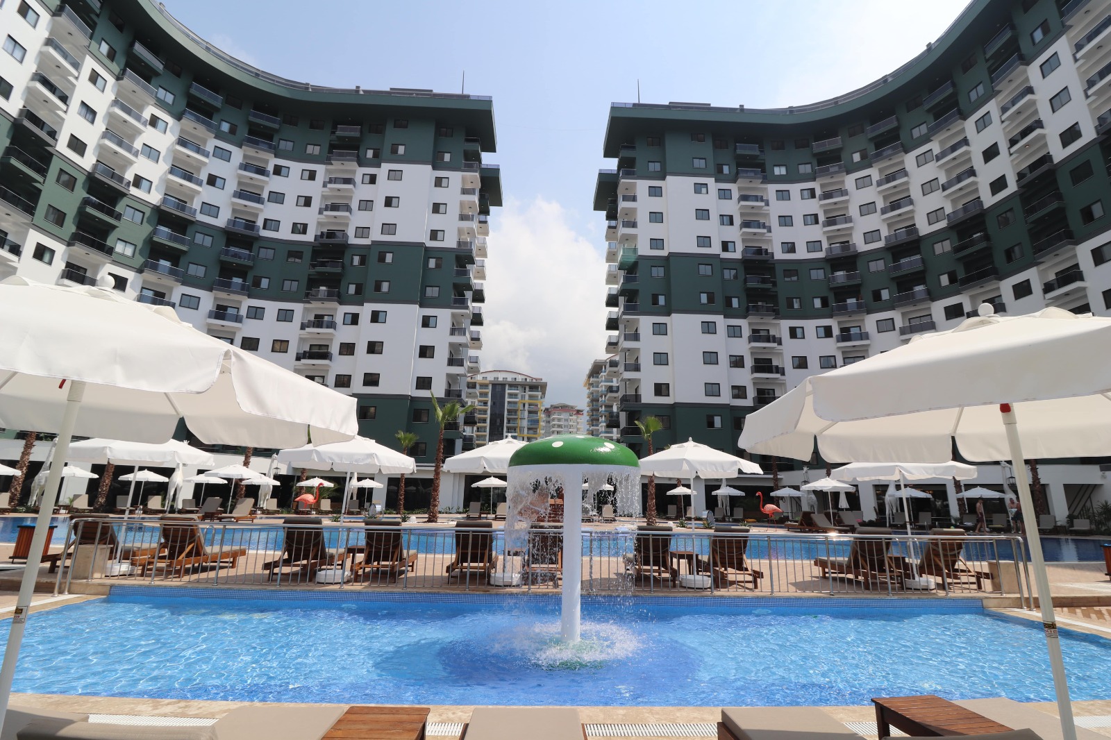 Fountain and white umbrellas by an outdoor pool for residents of apartments in Mahmutlar, Turkey