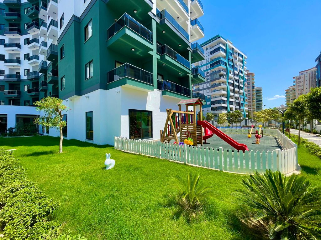 Children’s play area with a slide and swings for residents of apartments in the complex