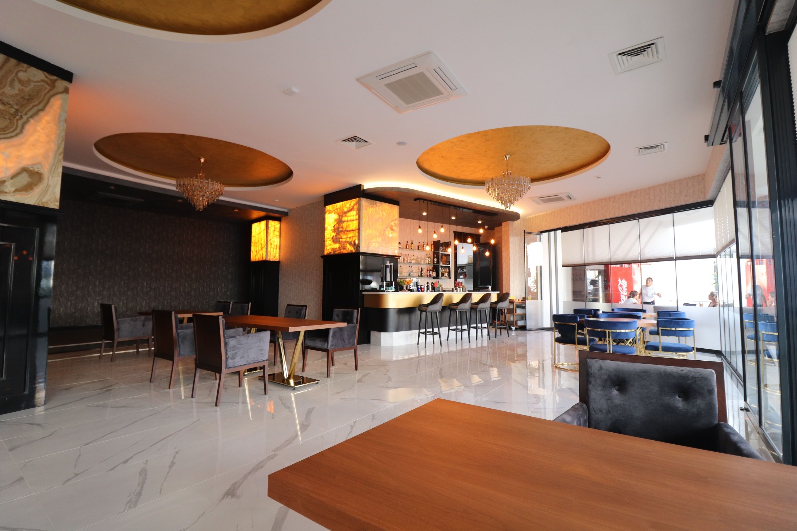 Bar counter and dining tables in a restaurant in a complex with apartments