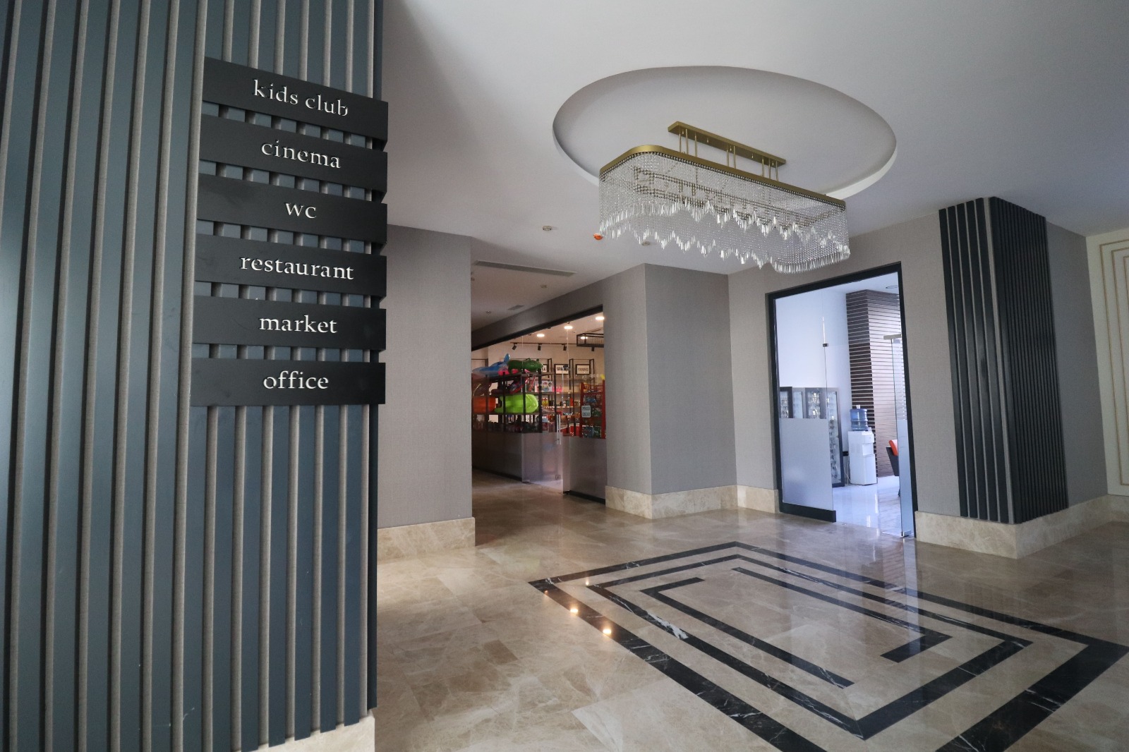 Lobby with patterned marble flooring and a chandelier where apartments are for sale